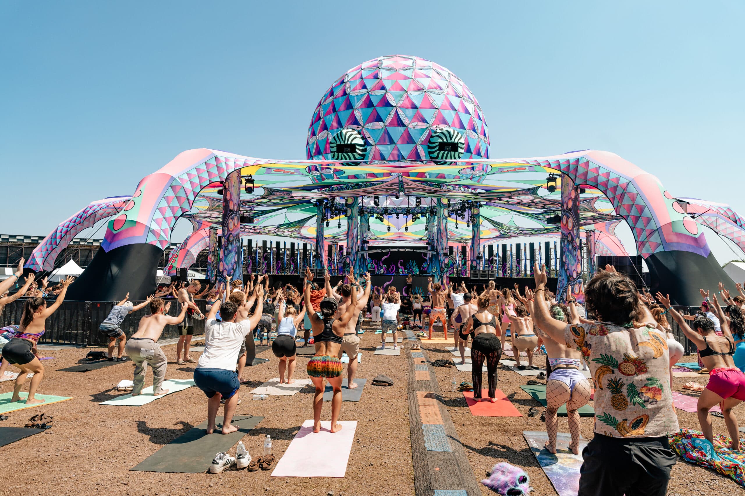 Partygoers doing yoga at an outdoor festival
