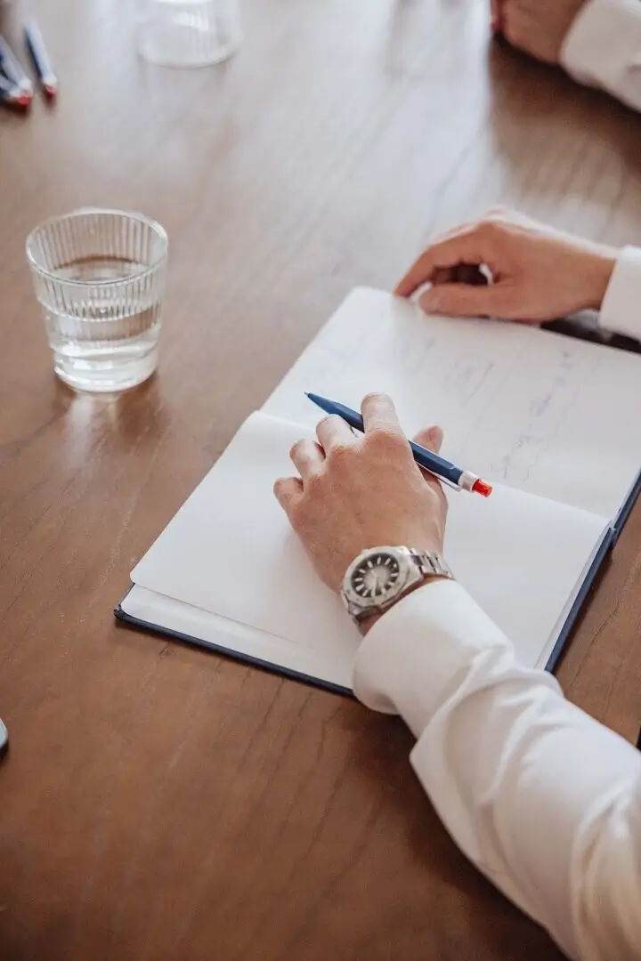 Professionelle Gastronomie- & Interieur-Fotografie: Gemütliche Lounge-Ecke mit rotem Sessel und beleuchteter Wein-Präsentation, inszeniert mit warmem Ambient-Licht und Fokus auf Design-Details.
