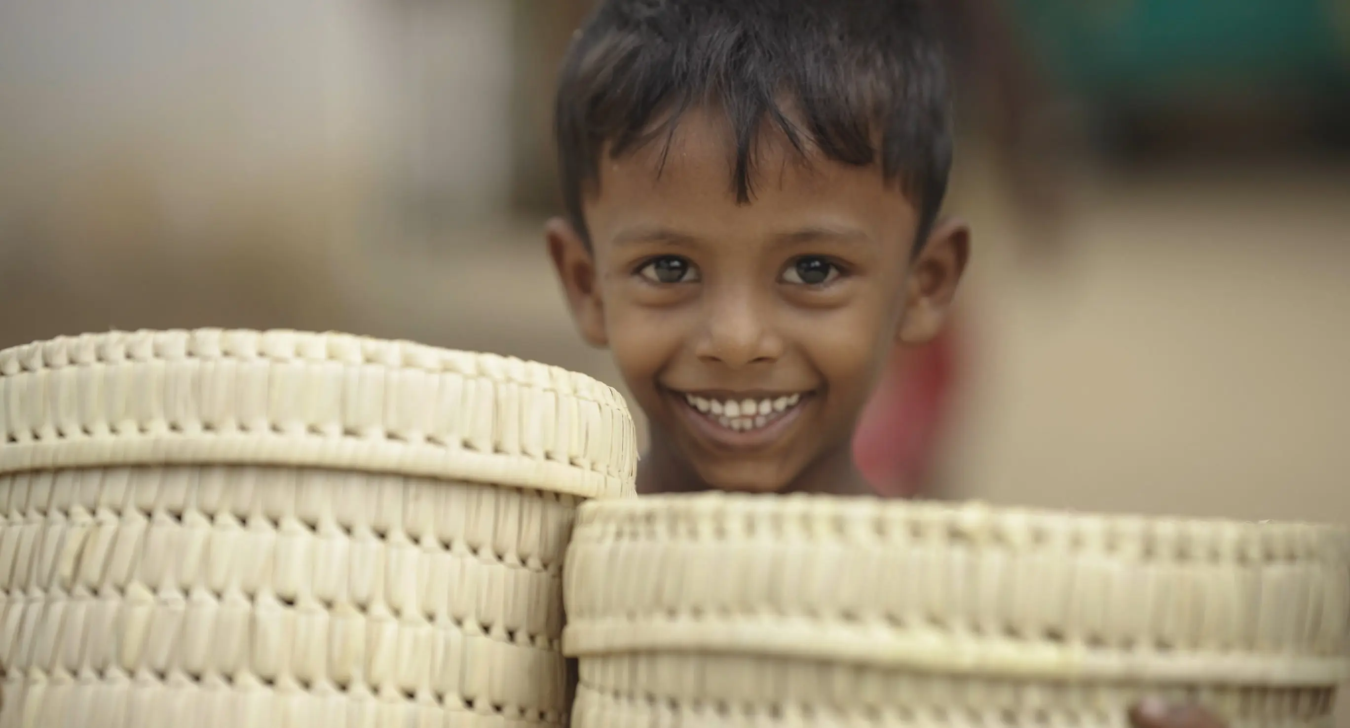 A child smiling over a set of handmade baskets