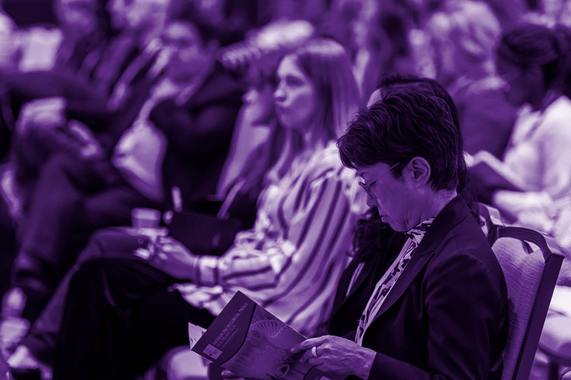 An attendee reads a delegate pack I created for Annual Outsourcing in Clinical Trials UK 2024 (credit: Arena International Events Group)