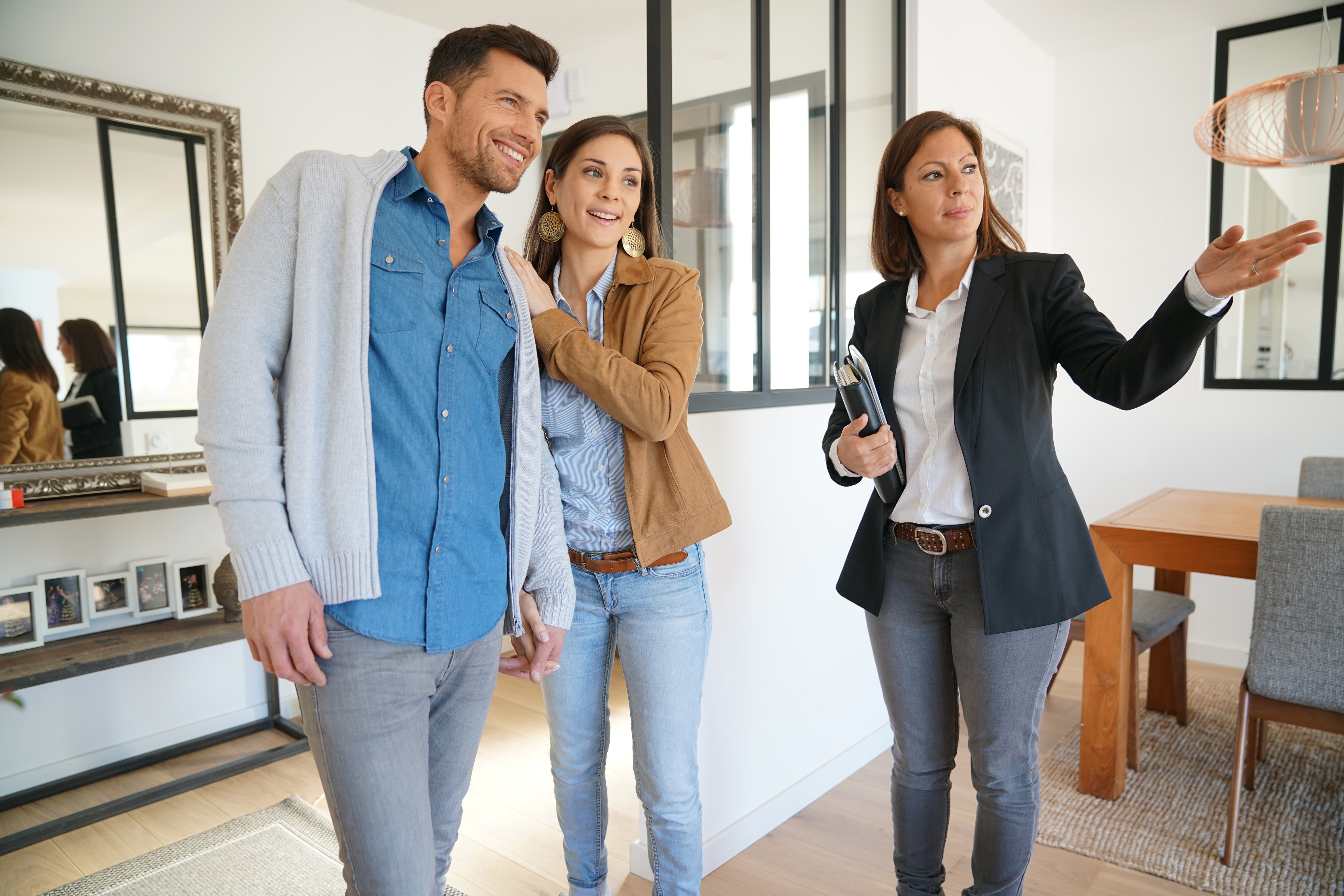 Real estate agent showing a property to new clients