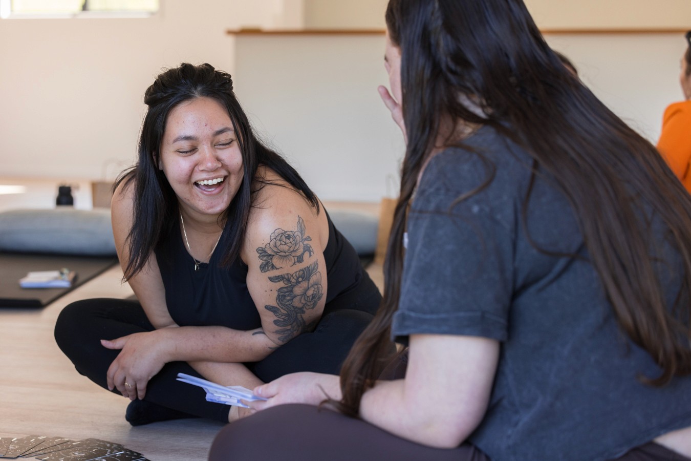 Woman sitting on floor laughing with friend