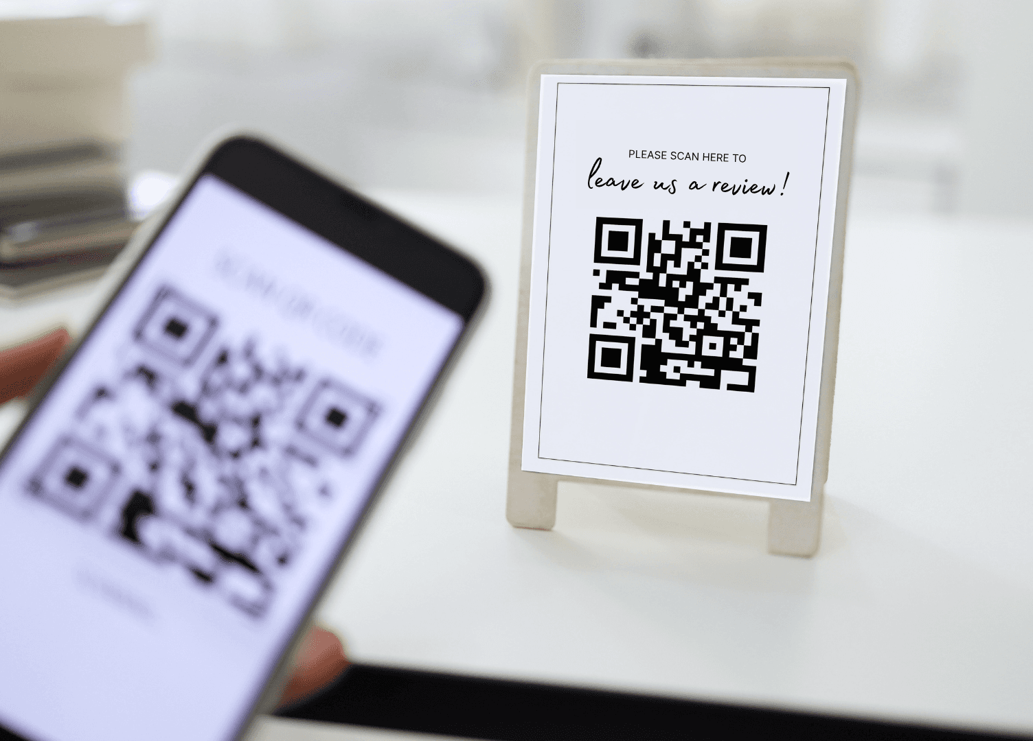 Client scanning a QR code card at a reception desk to leave a Google review after an appointment