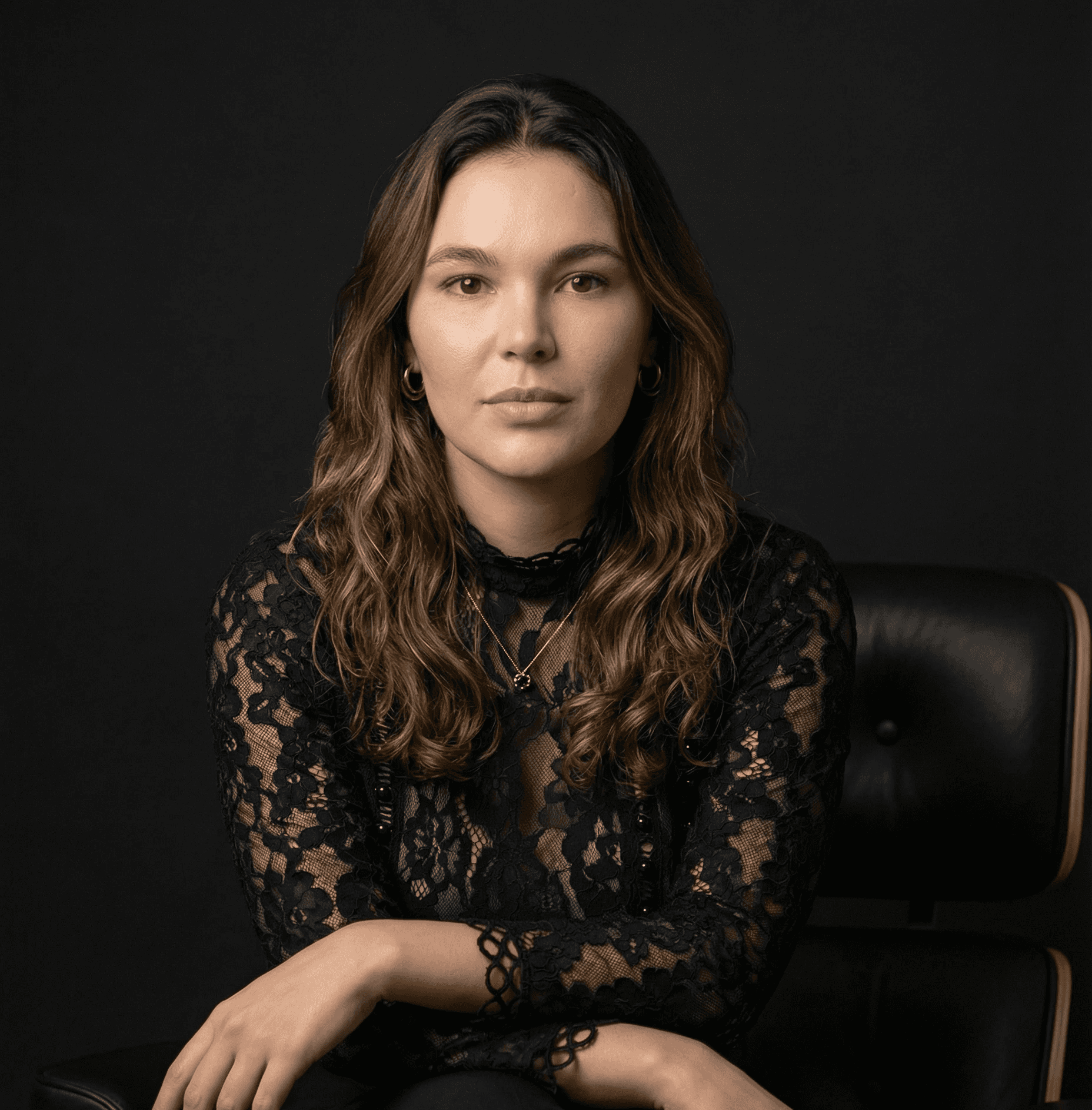 A woman in a business suit standing with her arms crossed