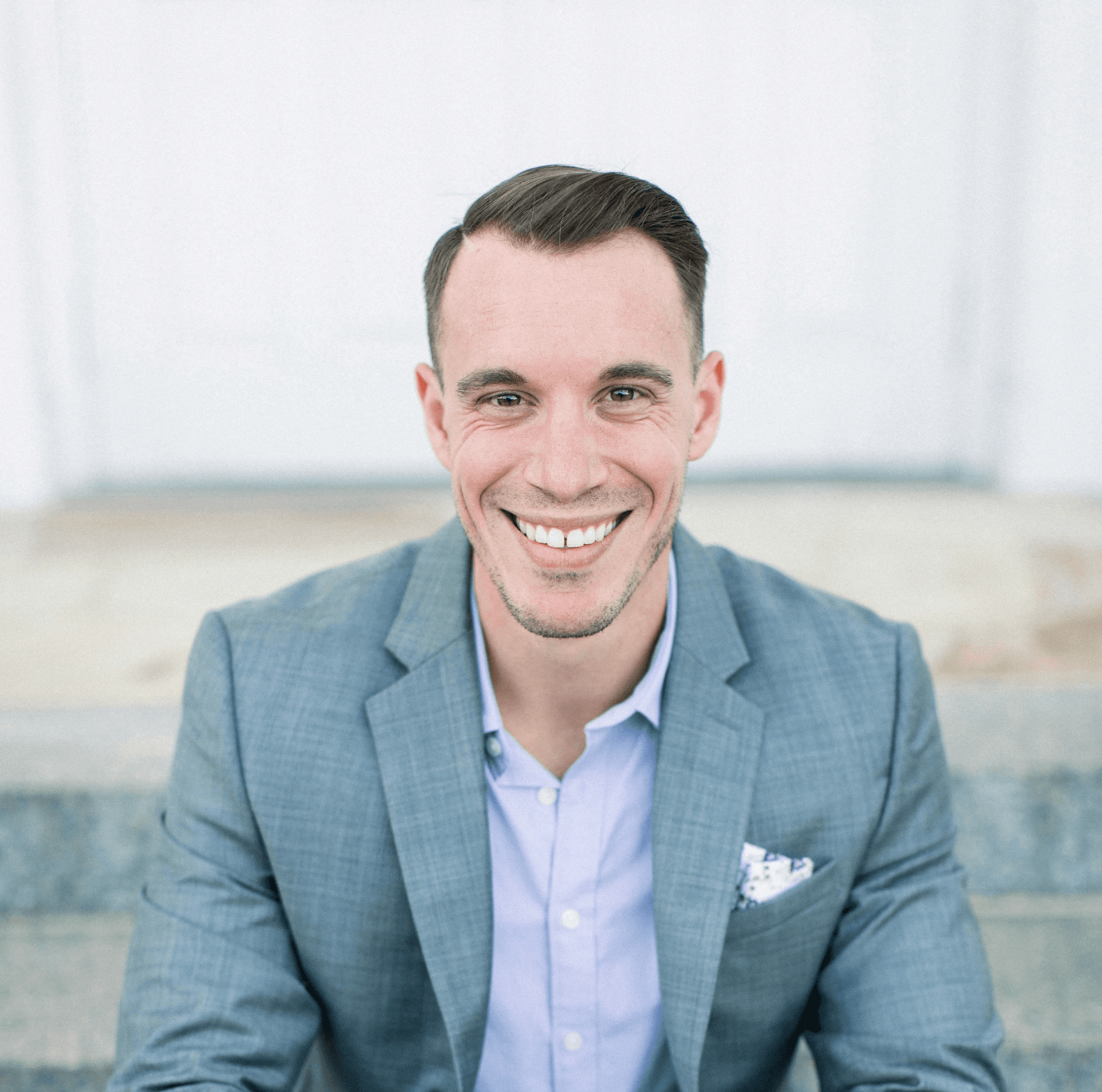 man in gray suit jacket sitting on gray concrete bench