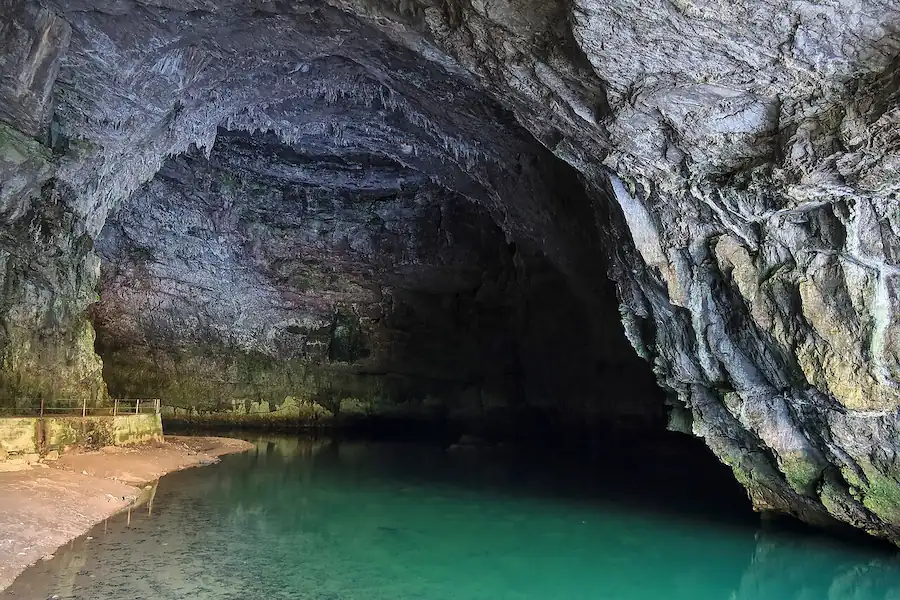 River flowing into a huge cave entrance at Planina cave, Slovenia.