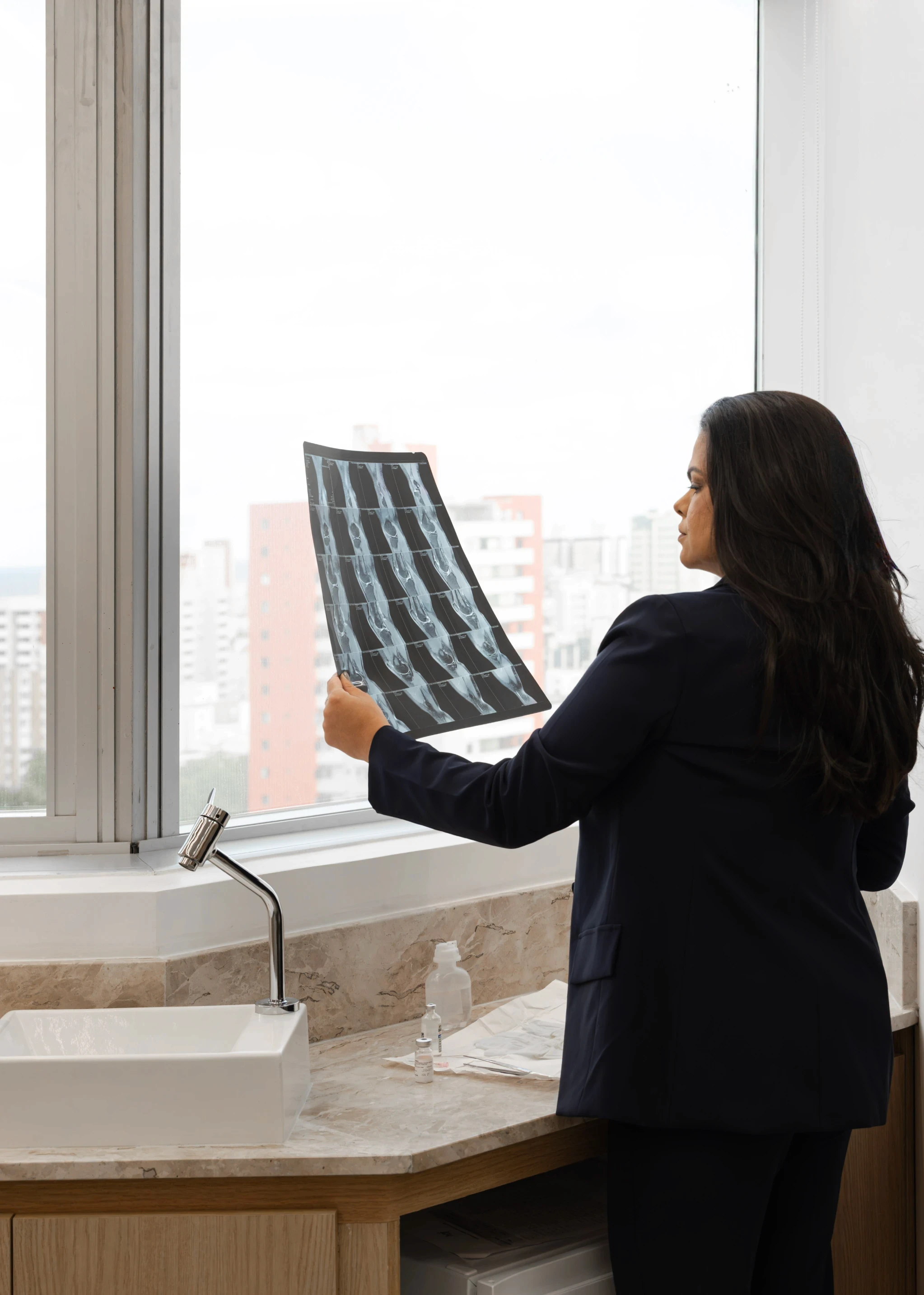 woman in blue tank top standing beside white wall