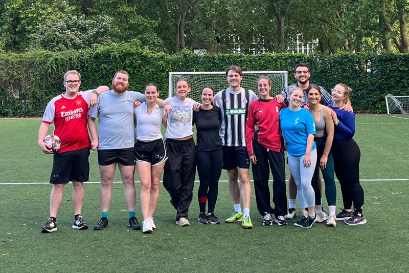 Group photo of Eulogy staff holding an England flag after an agency game of football