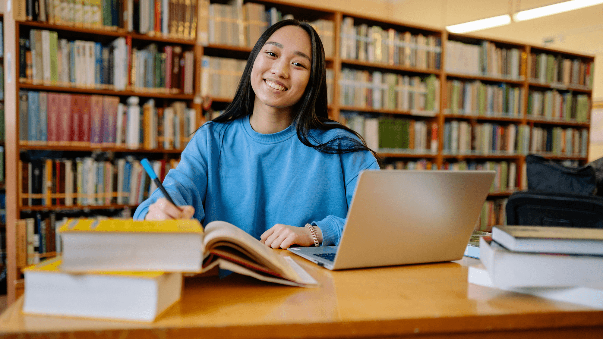Black and white photo of two people looking at a computer screen with papers on wall