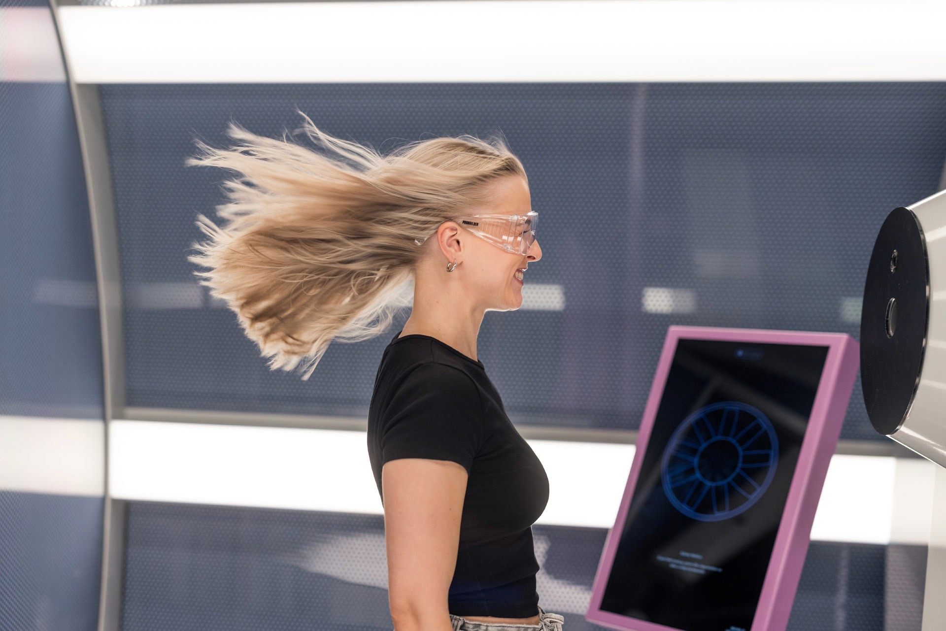 Ung flicka står i en vindtunnel