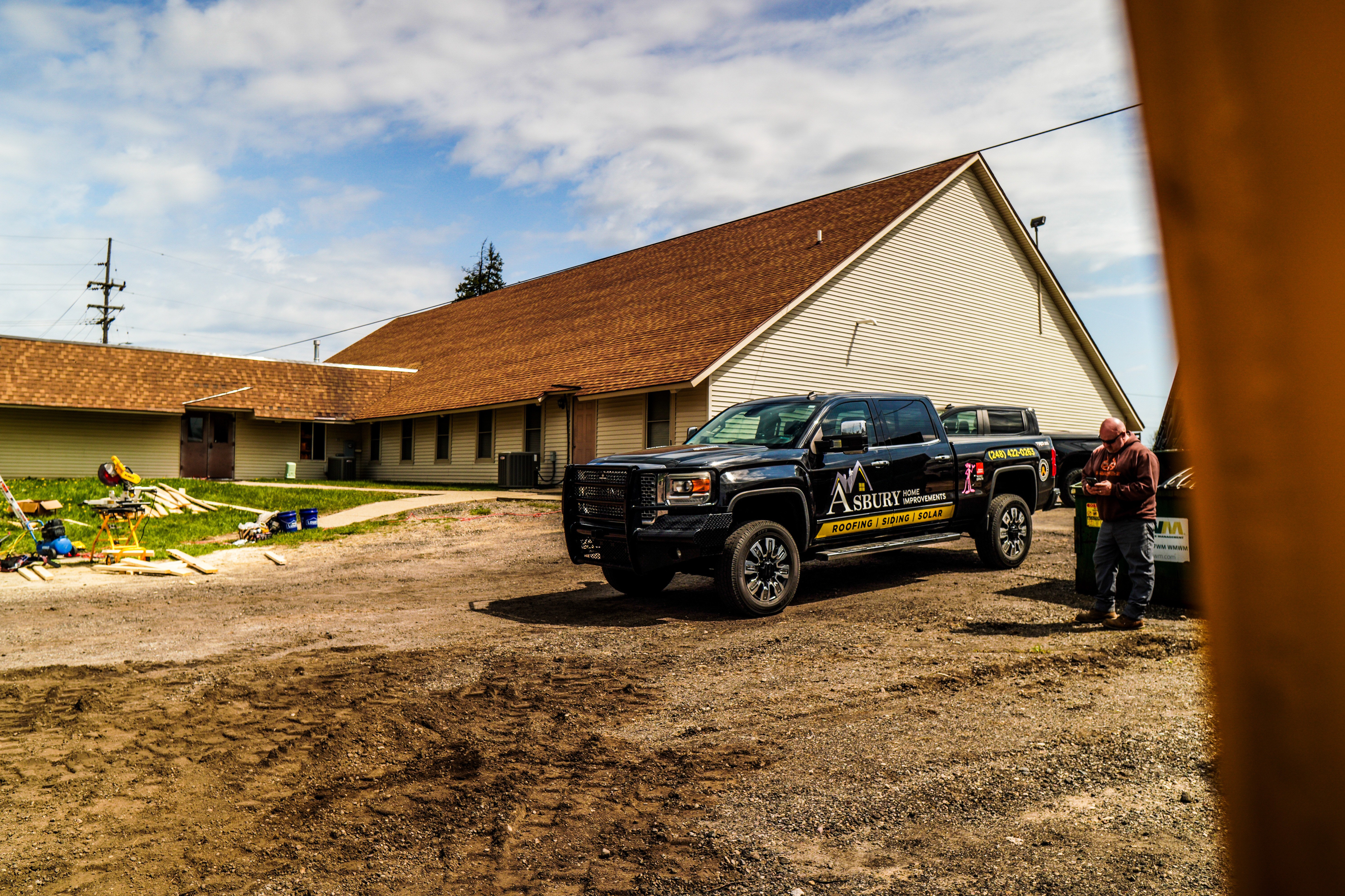 Asbury Roofing & Solar truck at a residential job site