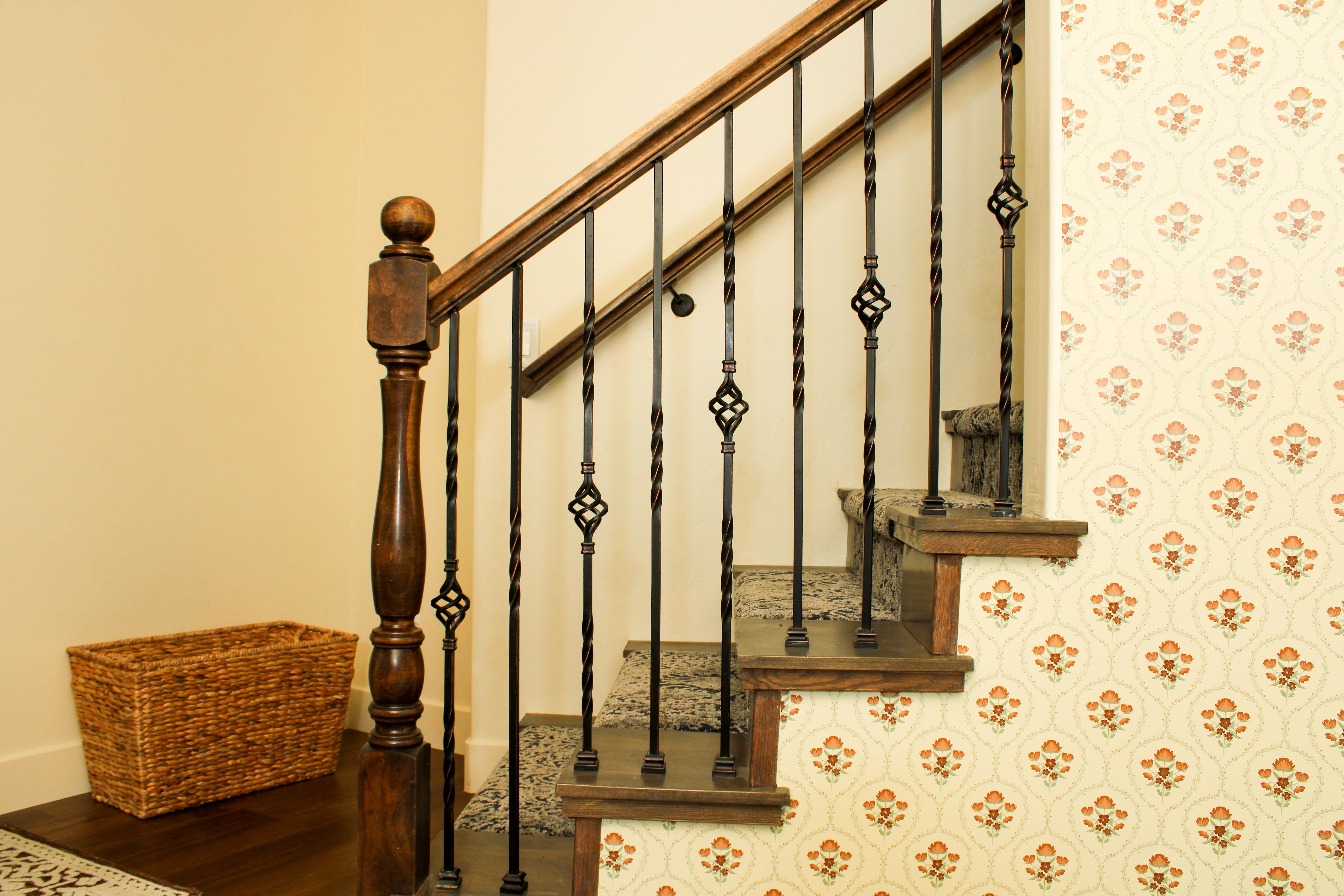 Custom staircase railing next to decorative wallpaper in a Southern Utah remodel, highlighting design details