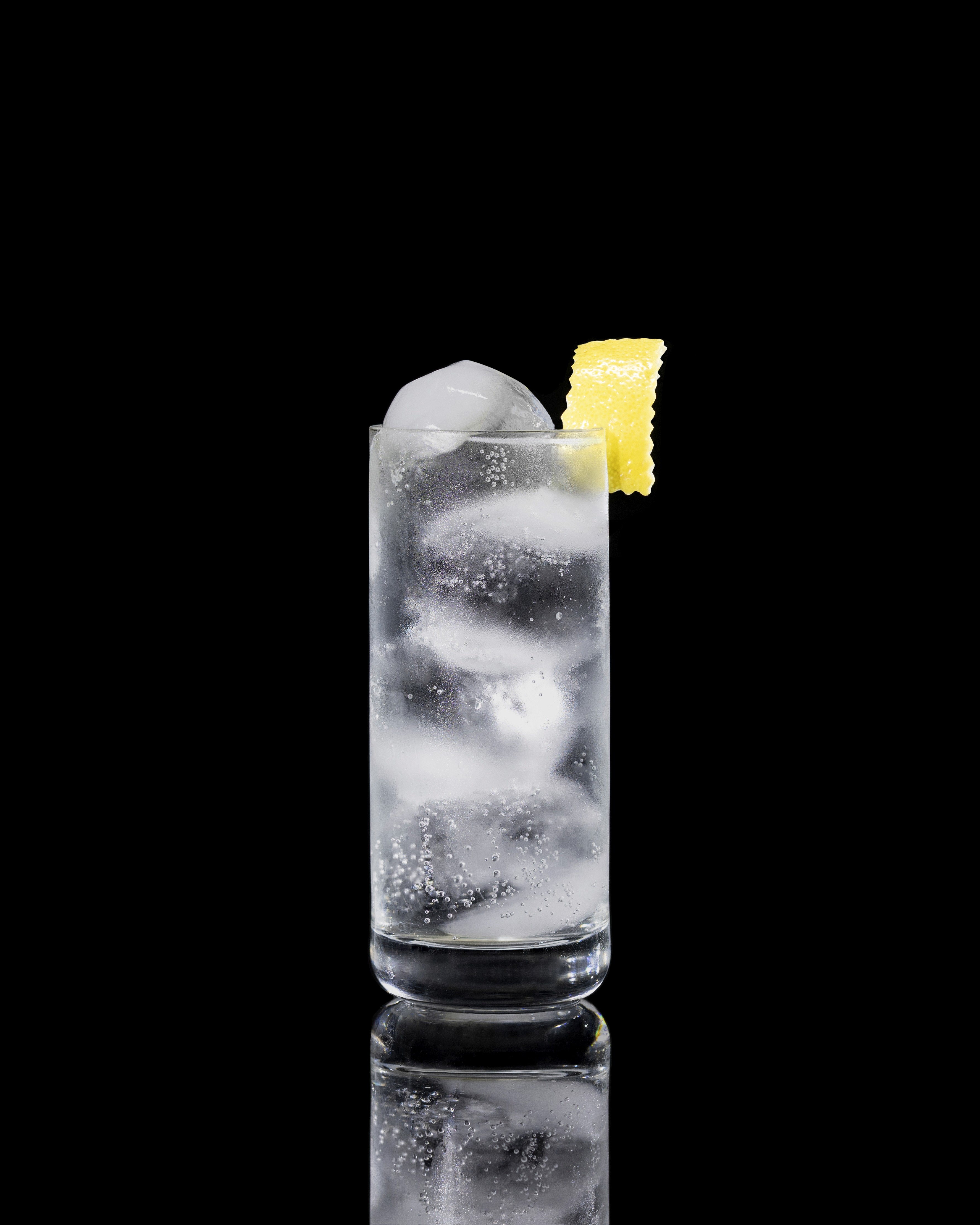 A closeup of a Vodka Tonic drink against a dark background.