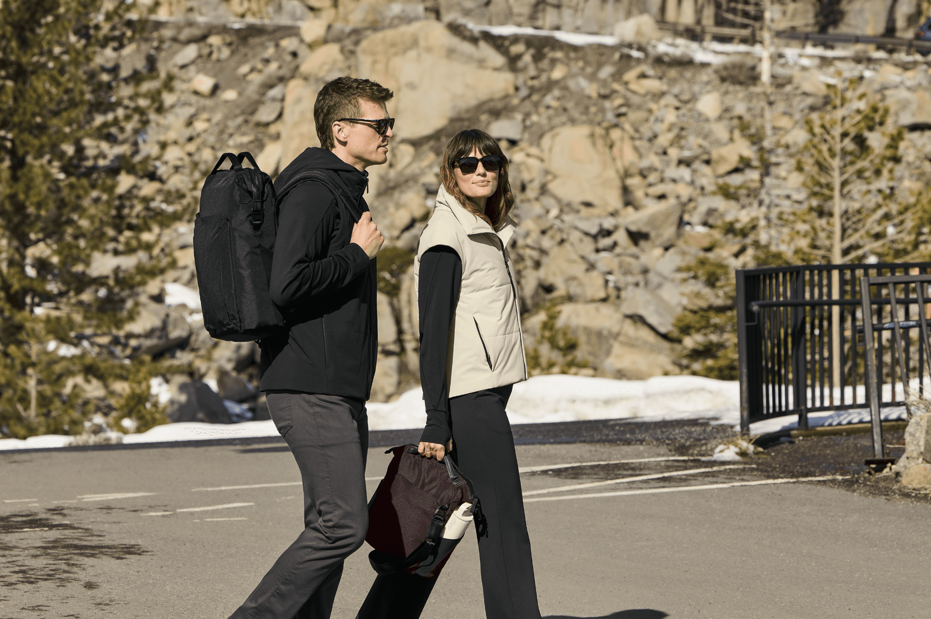 2 people walking in MiiR apparel in a snowy landscape on asphalt.