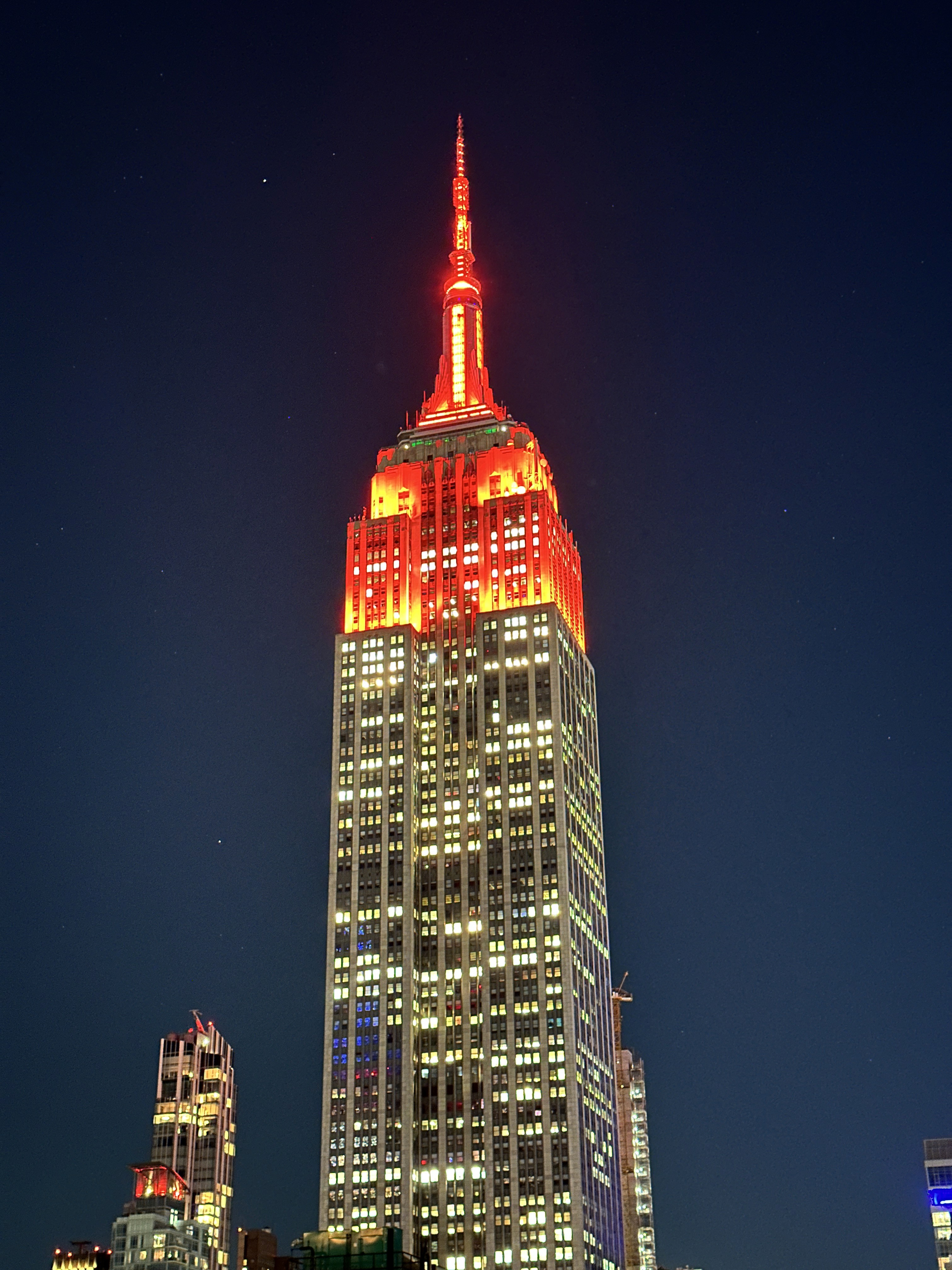 People playing soccer on a rooftop court surrounded by city buildings