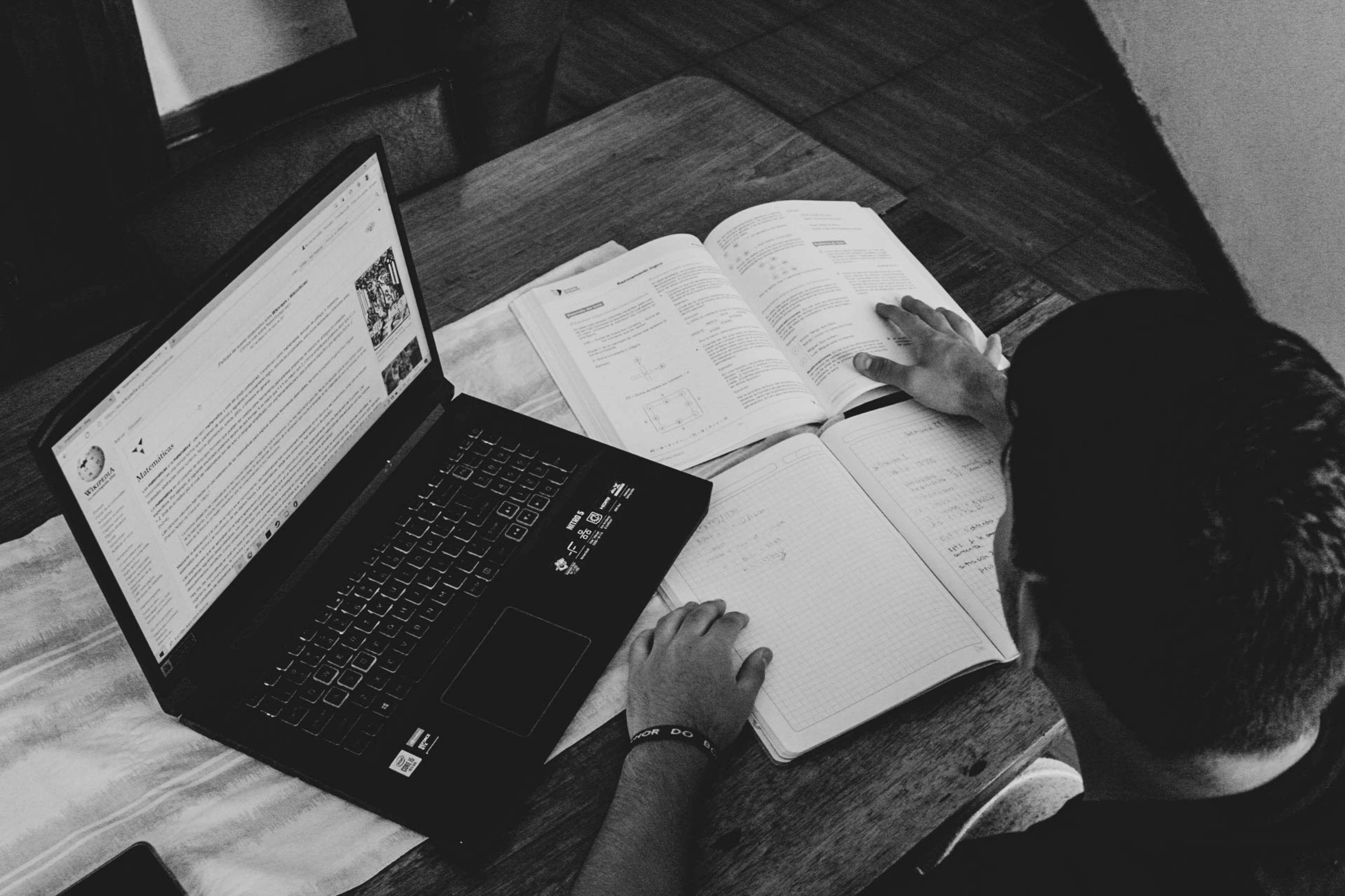 boy sitting with a opened laptop and copy - essay format