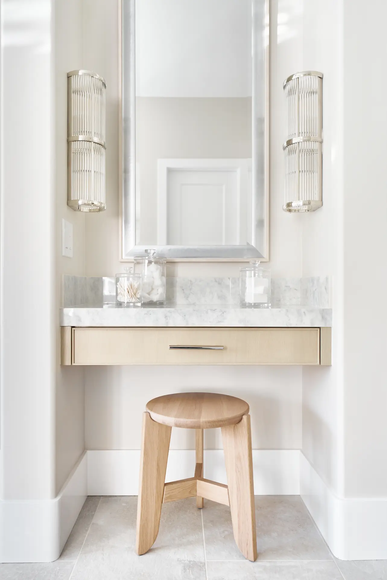Portrait view of the built-in makeup vanity in the primary bathroom, featuring mirror and storage in the Irvine Contemporary Coastal Remodel. Photo by Todd Huge.