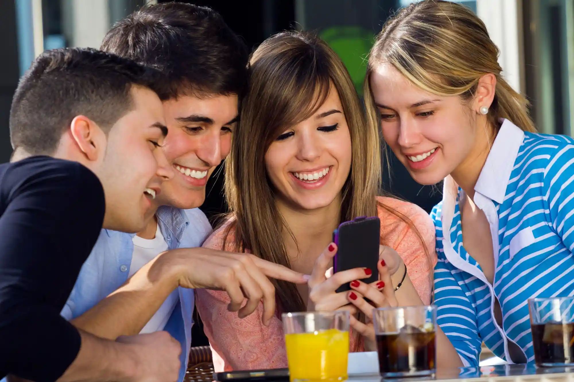 Gen Z friends watching microdrama content on smartphone together, representing shift from traditional TV to social video platforms