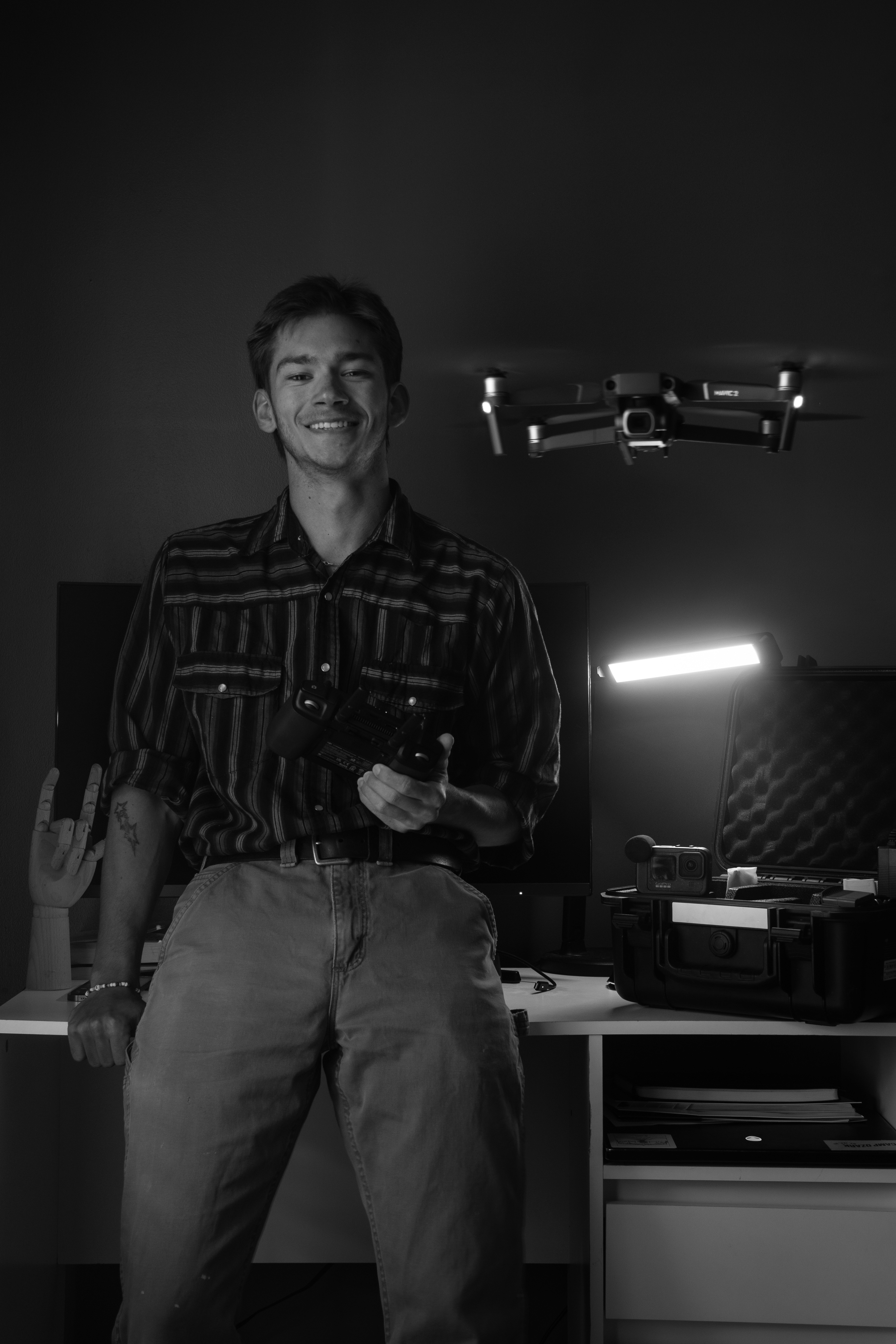 Drone operator posing with airborne drone looking at the camera