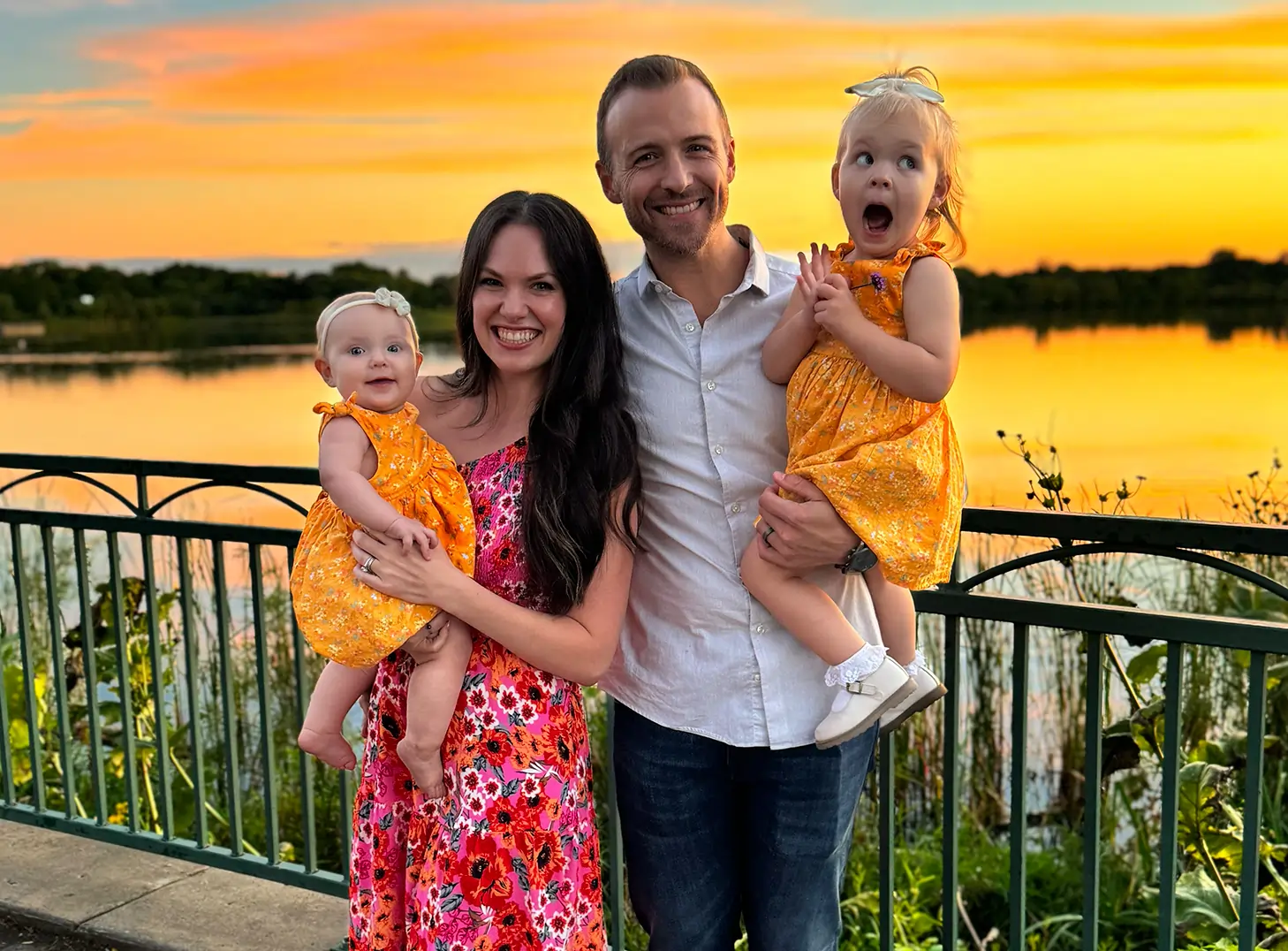Family photo of the founders and their daughter with a sunset backdrop. 