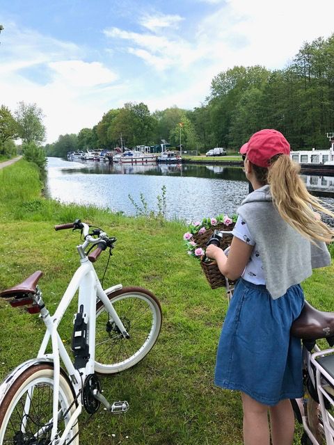 Frau mit Fahrad am Kanal