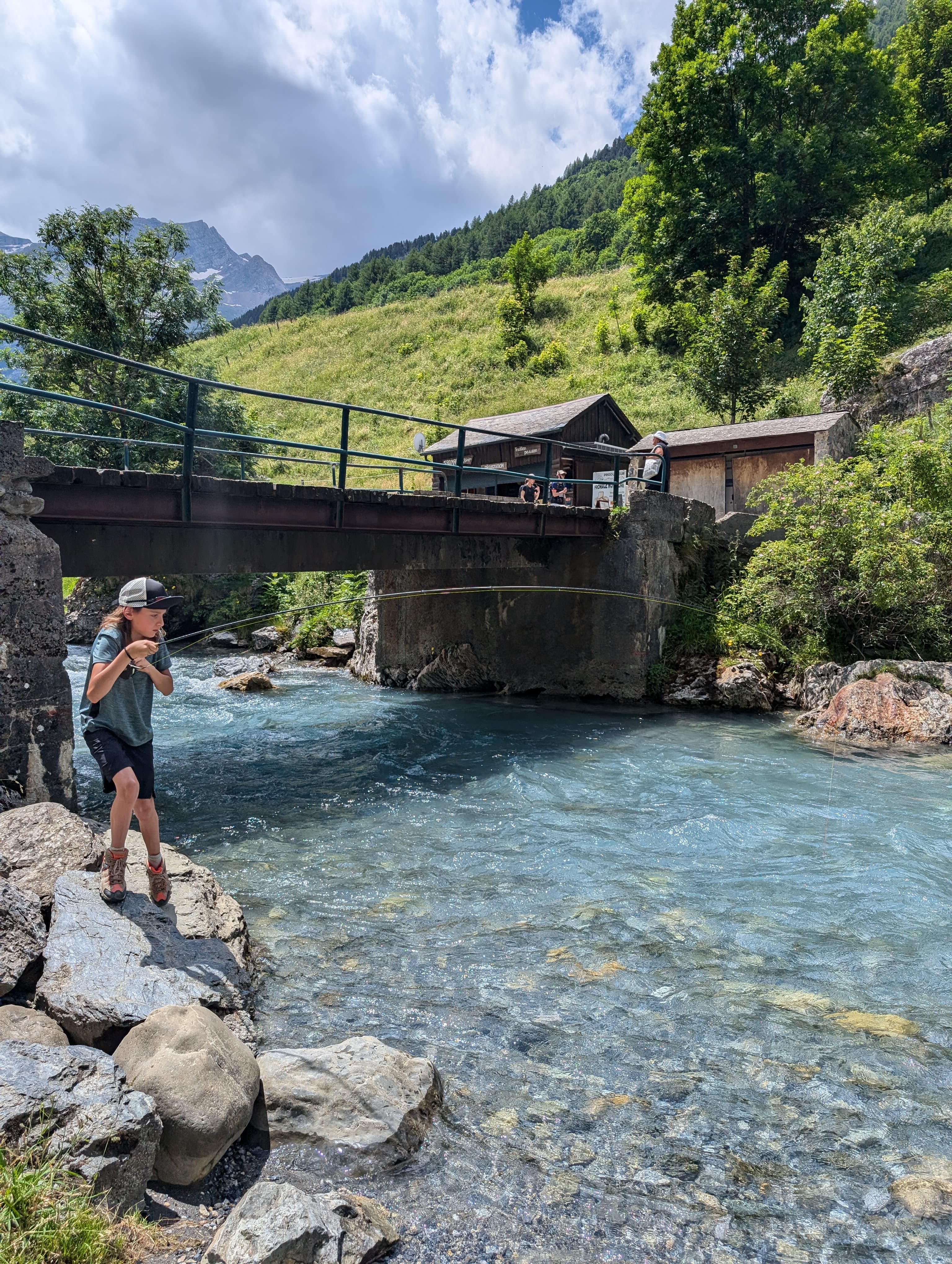 French nymphing in the Pyrenees: an angler casting with a long rod and tungsten nymphs in a clear stream.