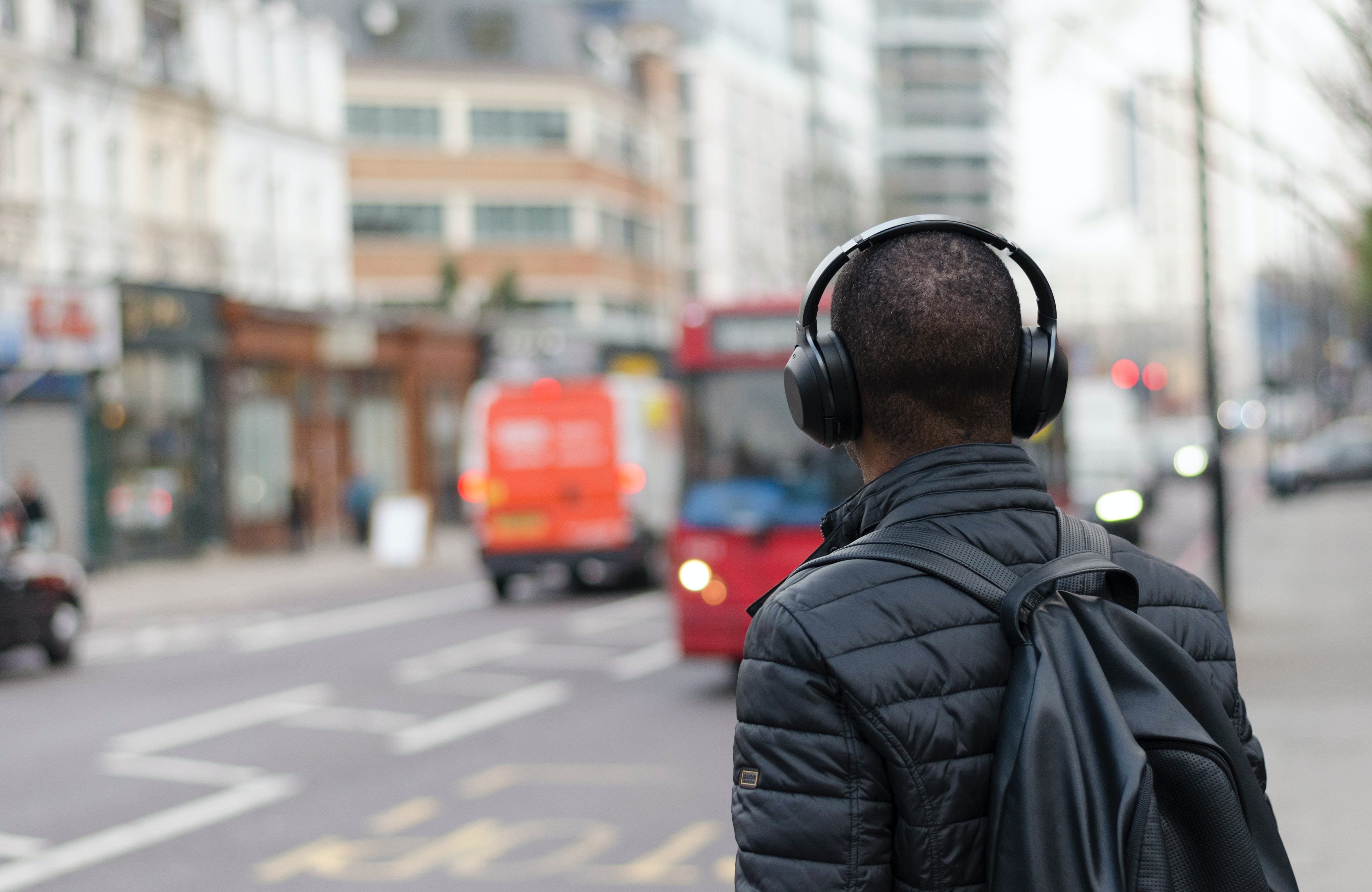 Man with headphones walking on street - best AI songs