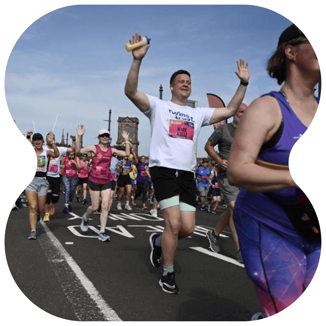 Crowd of runners participating in an outdoor running event on a closed road.
