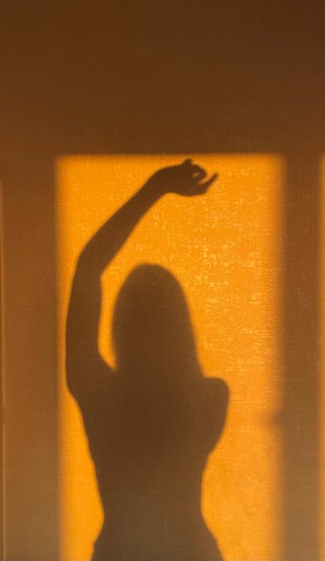 A wooden essential oil diffuser releasing a gentle stream of steam, surrounded by dried herbs and a small bottle of essential oil. The warm lighting enhances the cozy and therapeutic ambiance.