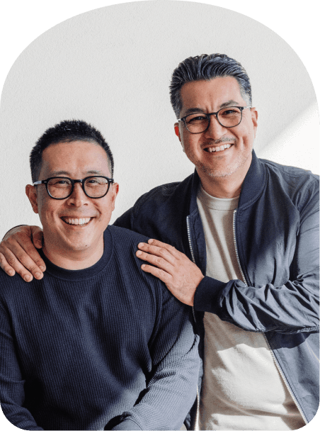 Hand holding a navy tote bag featuring four colorful geometric shapes and small βjeminiβ branding near the bottom.