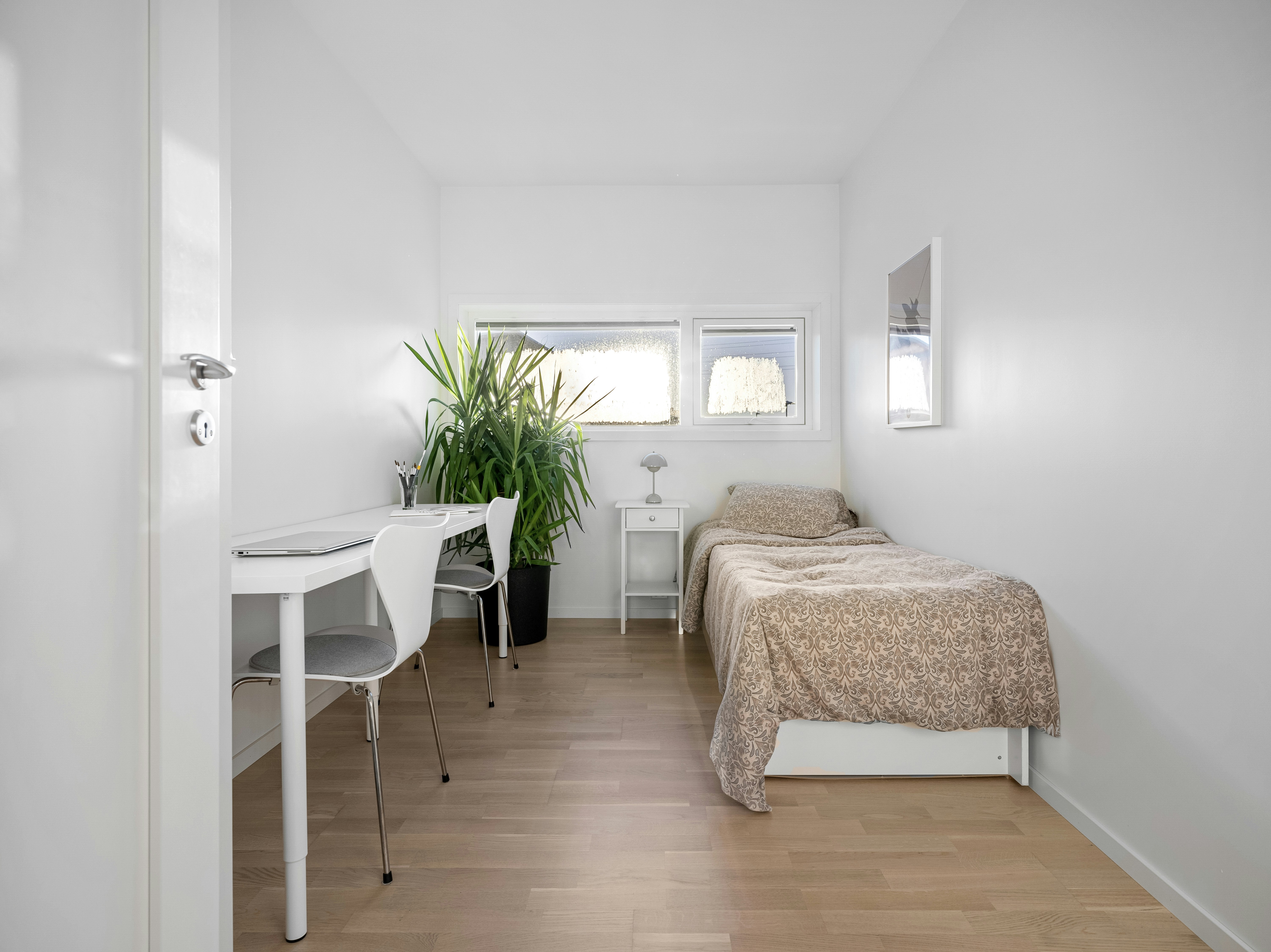 A room with a bed, desk, and chair in it