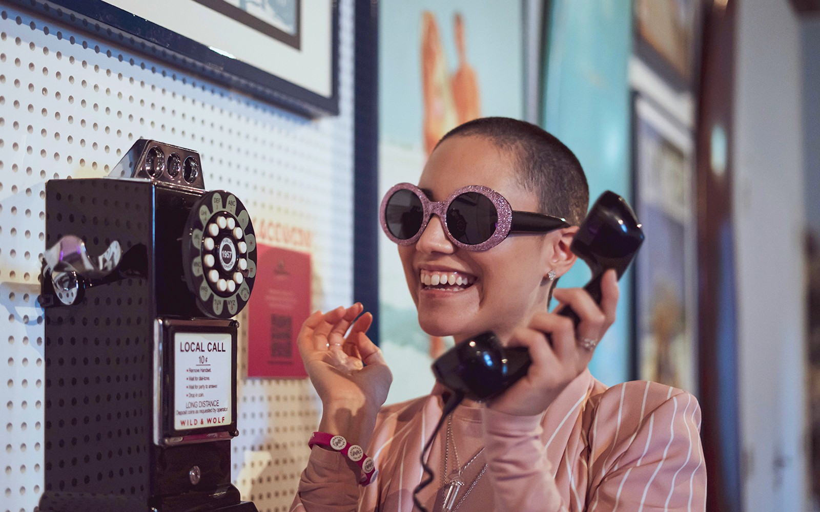 Személy használ régi telefont a Pink Palace kiállításon.