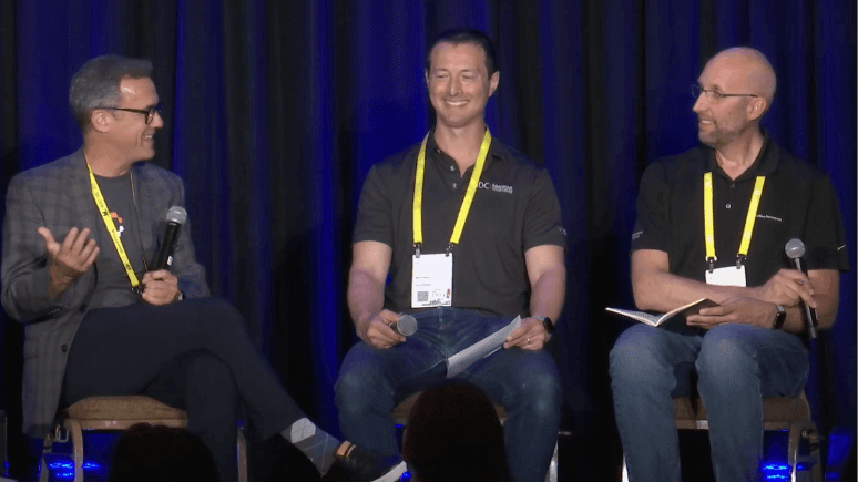 Jay Wright, James Cooper, and Ryan Wheeler sit on stage at AWE 2024, engaging in a panel discussion