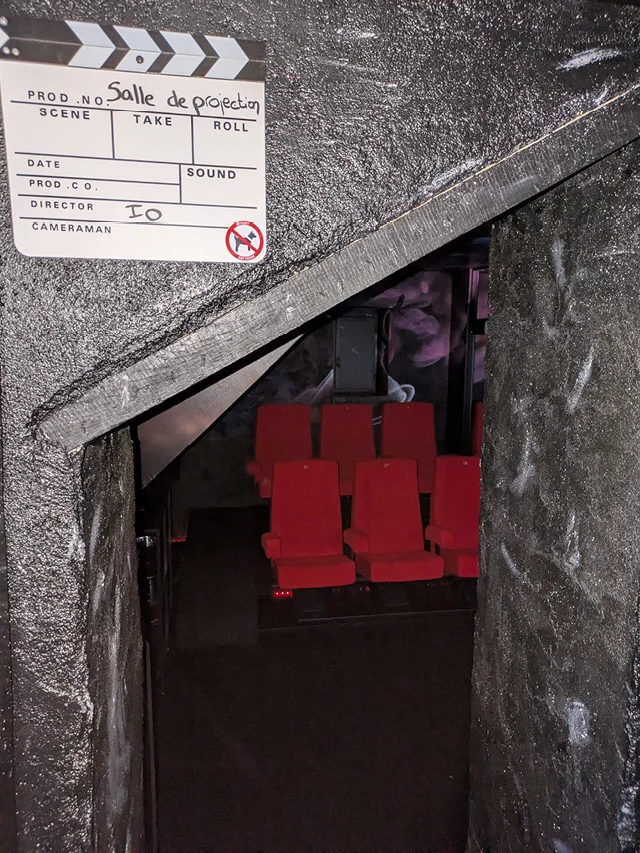 Entrée spécifique de la salle de projection IO avec vue sur la série de fauteuils rouge du gîte