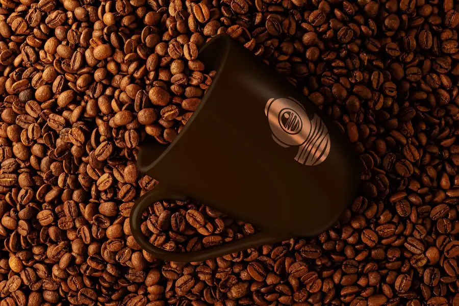 Copper Coffee Co. symbol printed on a dark mug resting on coffee beans