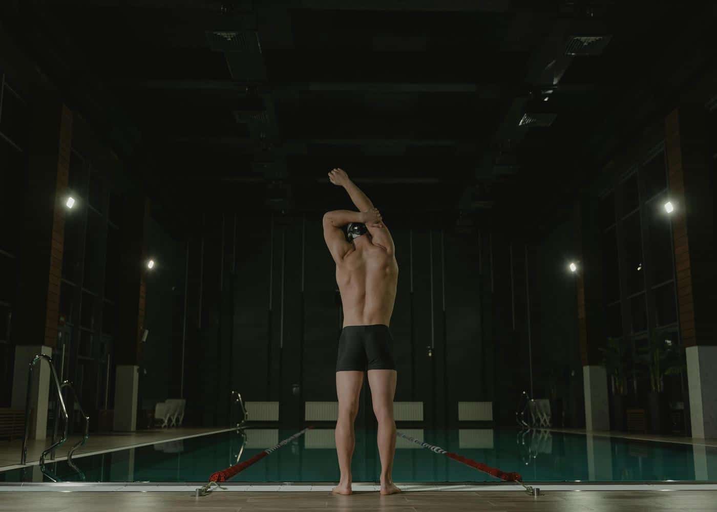 Man wearing swimming headphones and preparing to dive