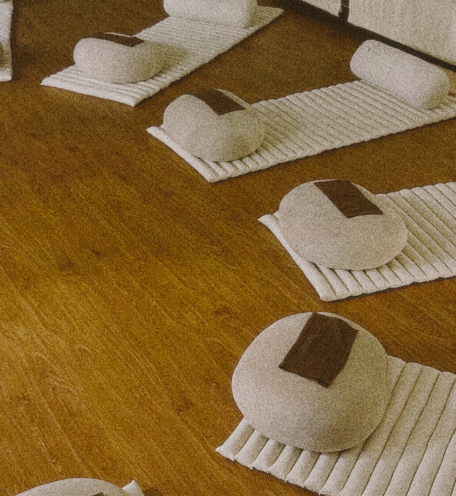 Sound bath setup at Kind Garden Bangkok studio — mats, cushions and eye shades on a wooden floor