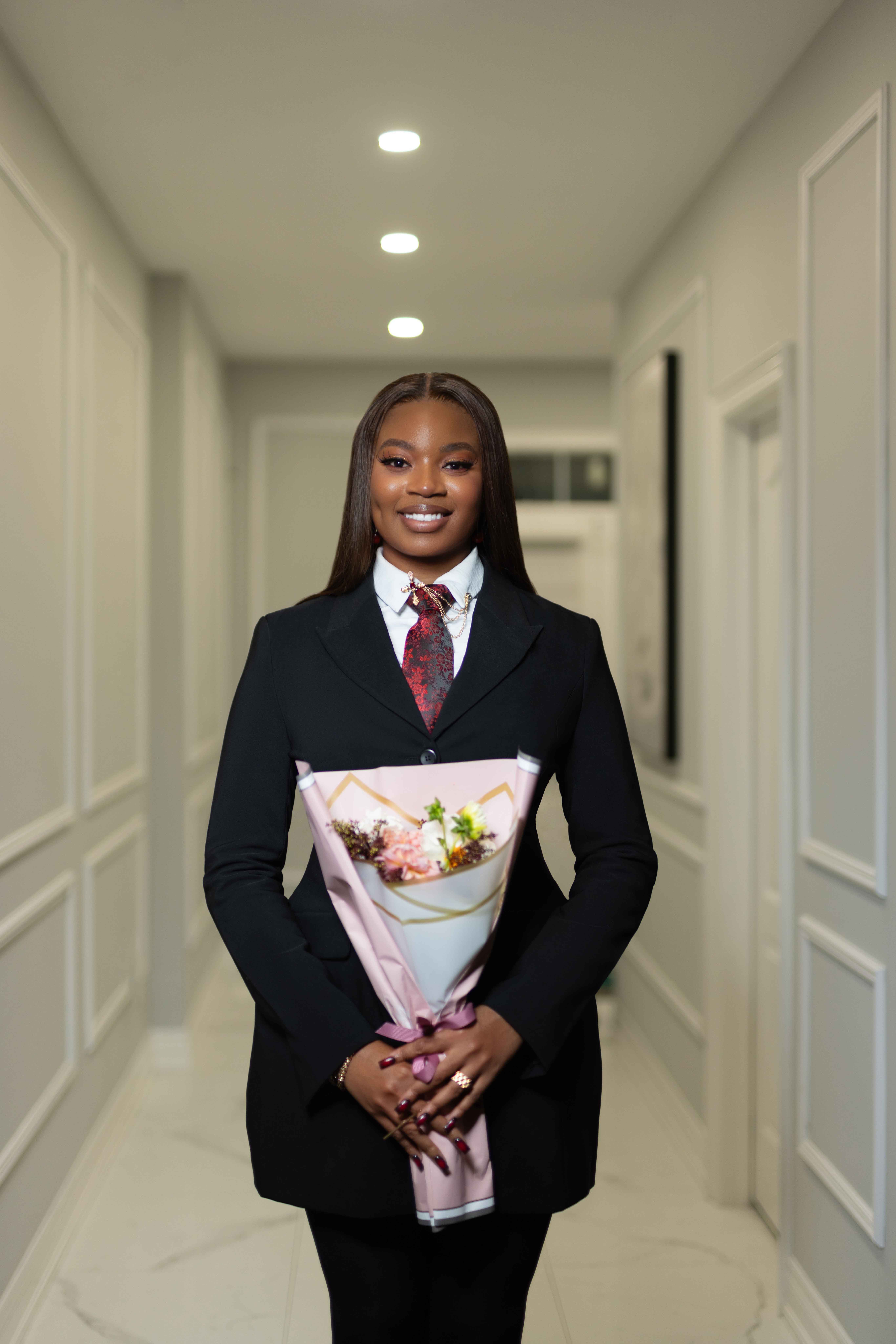 Editorial-style portrait of a woman in a hallway holding flowers