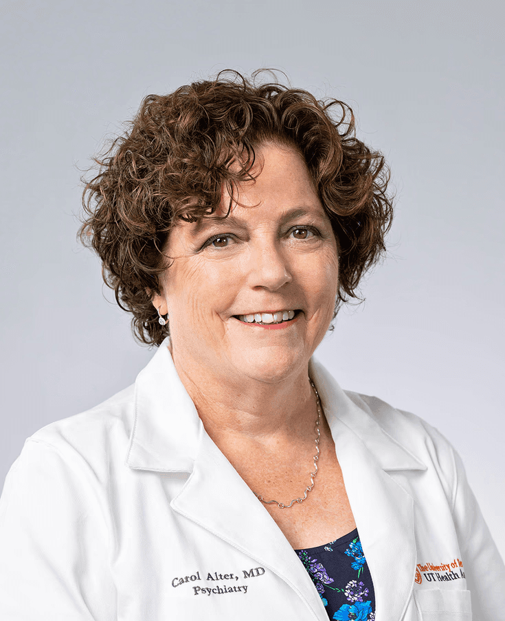 Carol Alter MD professional photo in a white medical coat with a white background