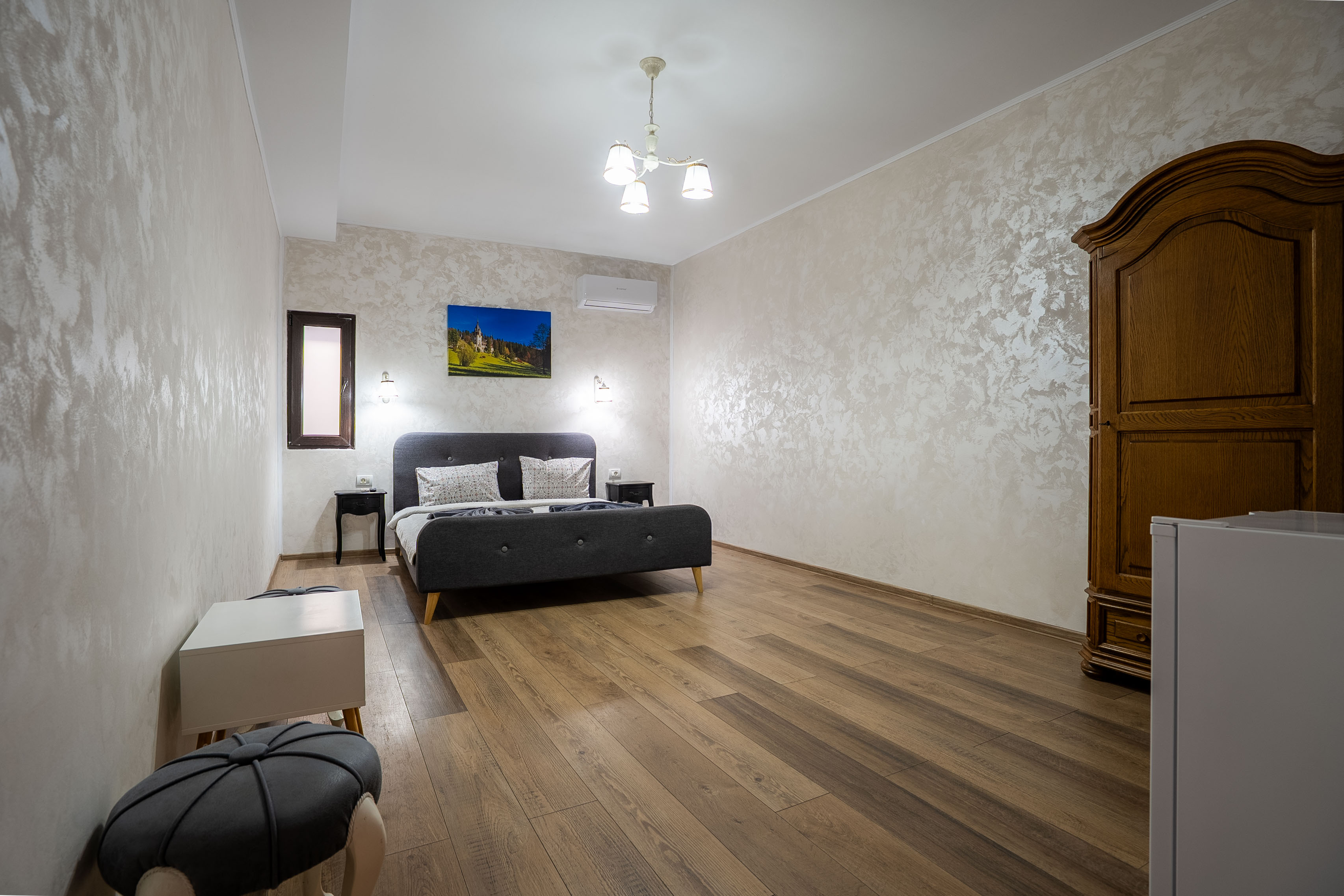 Modern bathroom featuring a walk-in shower, wooden vanity, round mirror, and elegant marble tiles.