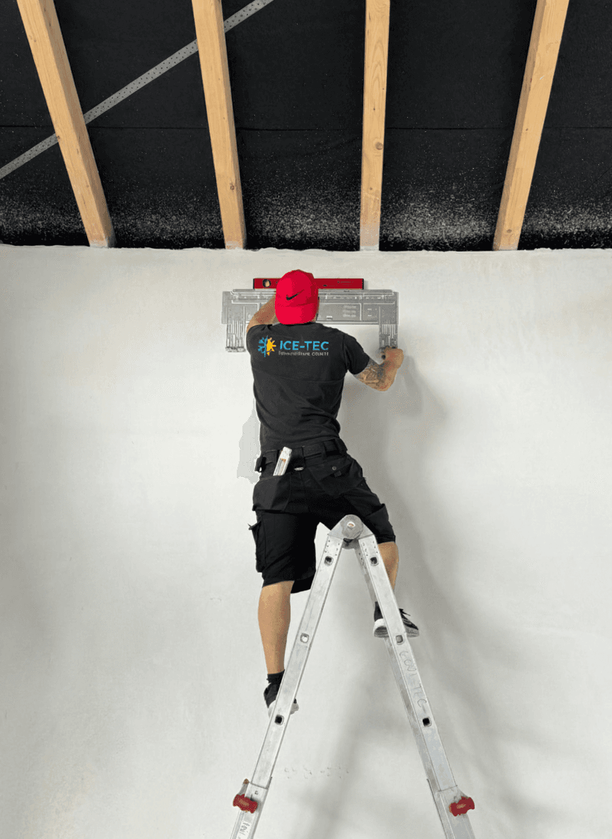 Professionelle Handwerksarbeit von ICE-TEC: Ein Monteur installiert sorgfältig die Basiseinheit für ein modernes Klimasystem. Das Bild zeigt den hohen Anspruch an eine saubere und technisch einwandfreie Ausführung nach Herstellervorgaben.