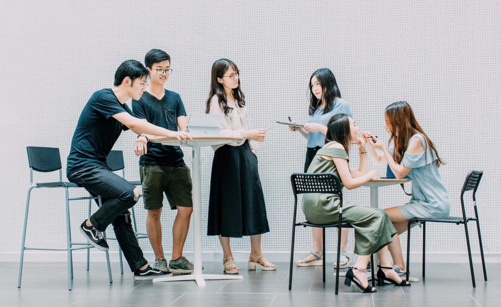 Group of young adults engaging in collaborative study session in modern office space.
