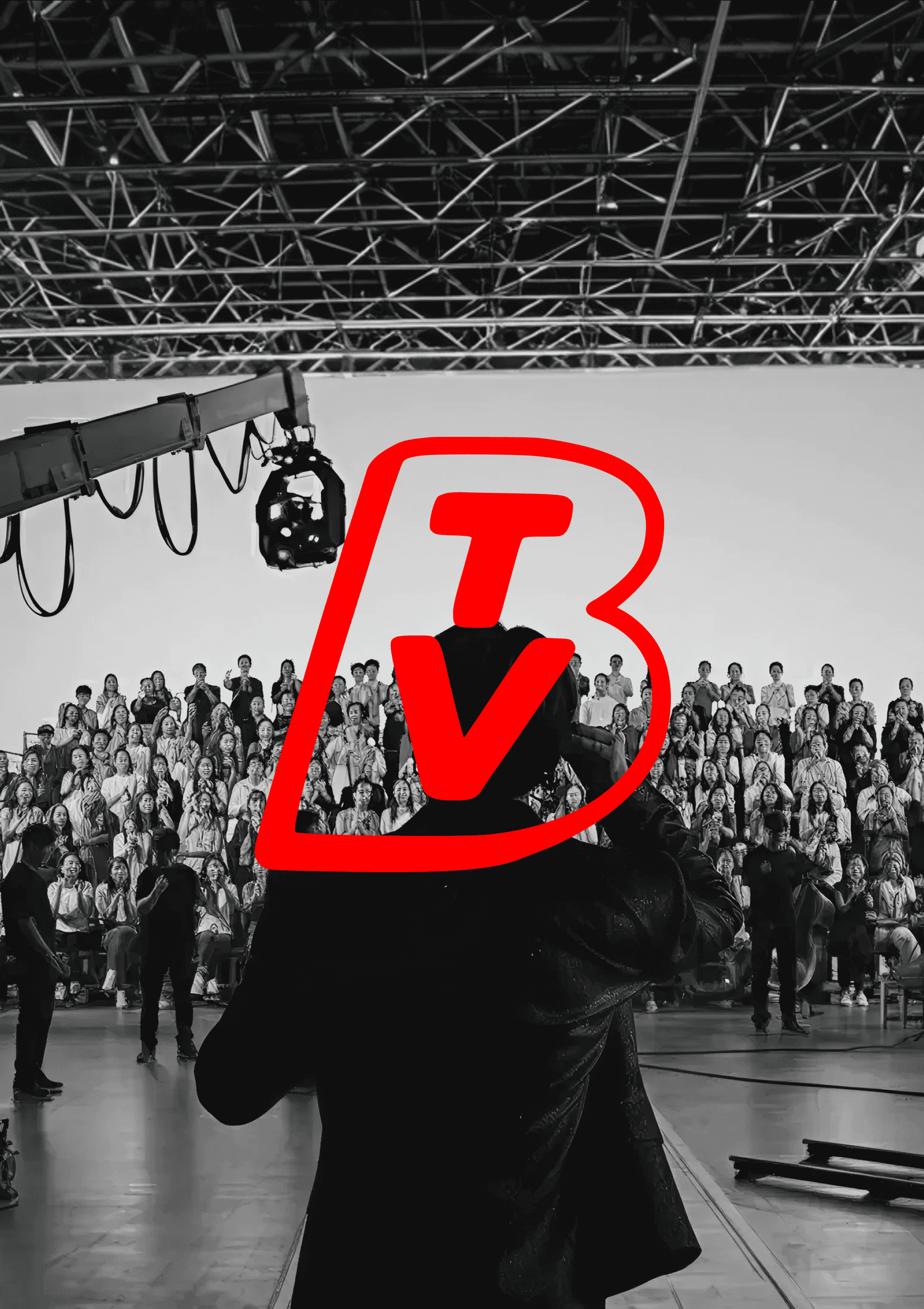A camera crane and professional lighting rig hang over a large seated audience in a broadcast studio, with the BrandTV logo overlaid in red
