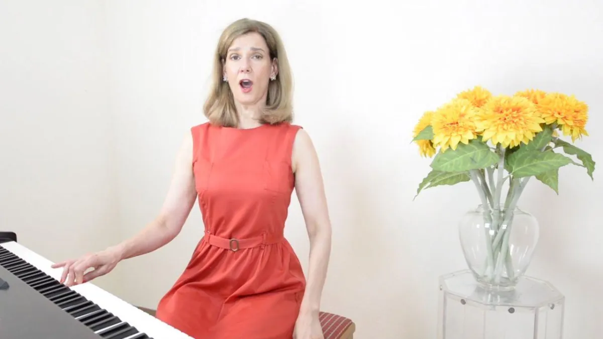 Danielle Zuber sitzt am Klavier und singt klassische Lieder zur Erweiterung des Stimmumfangs im Rahmen des 30-Tage-Kurses.