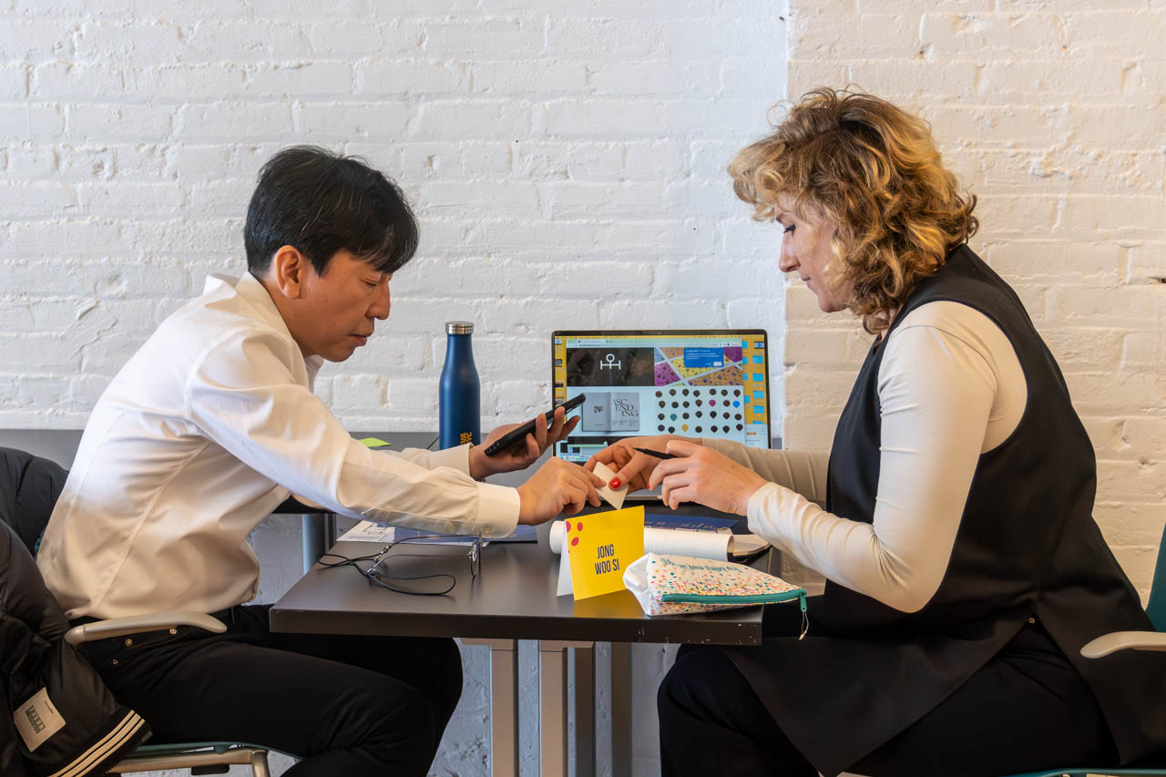 two people talking next to a computer