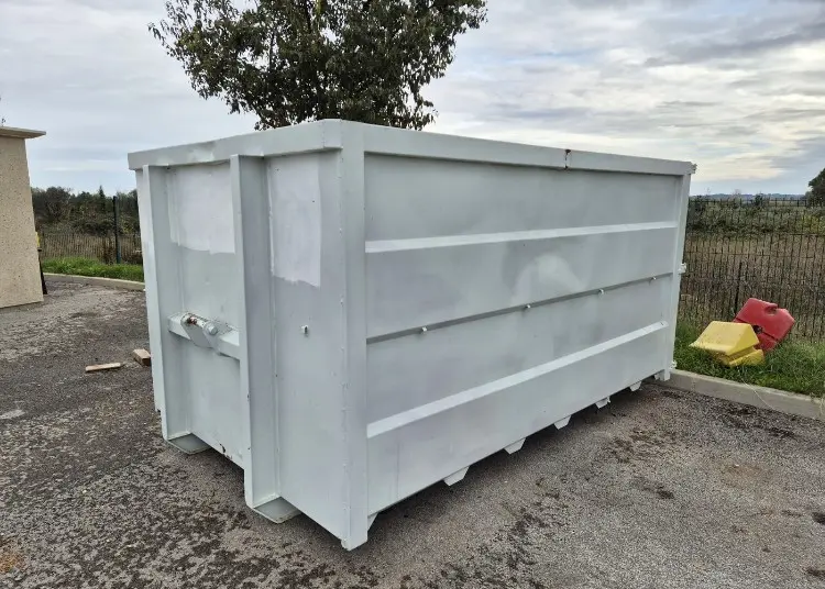 Benne blanche déposée sur une surface goudronnée