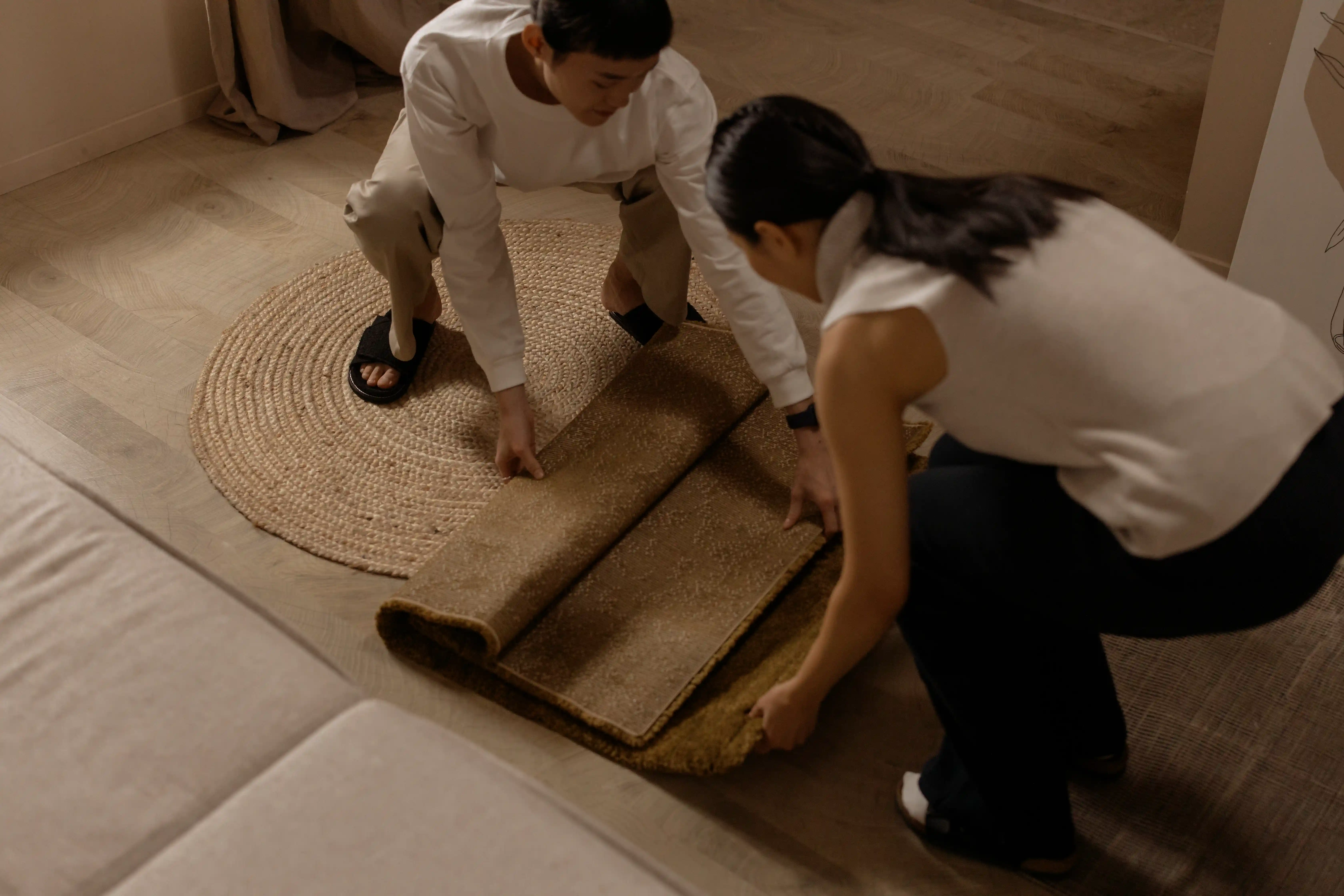 A scene of two ladies unfolding a floor mat
