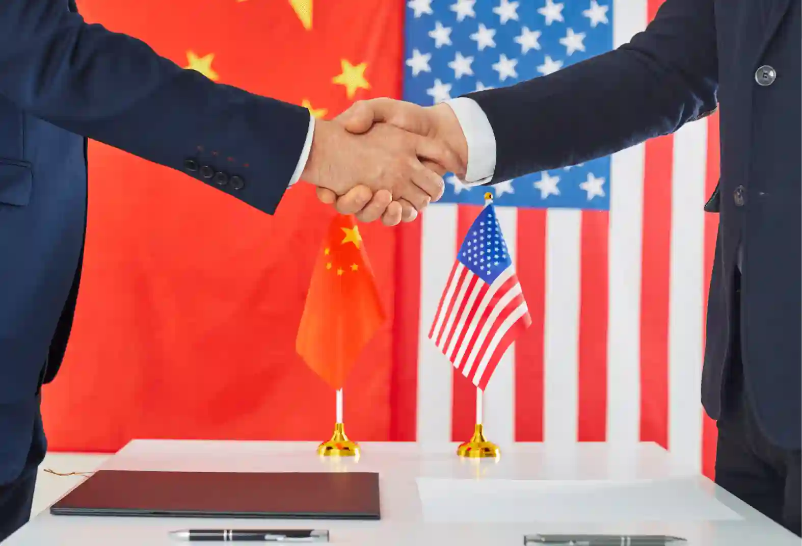 Close-up of US and China officials shaking hands.