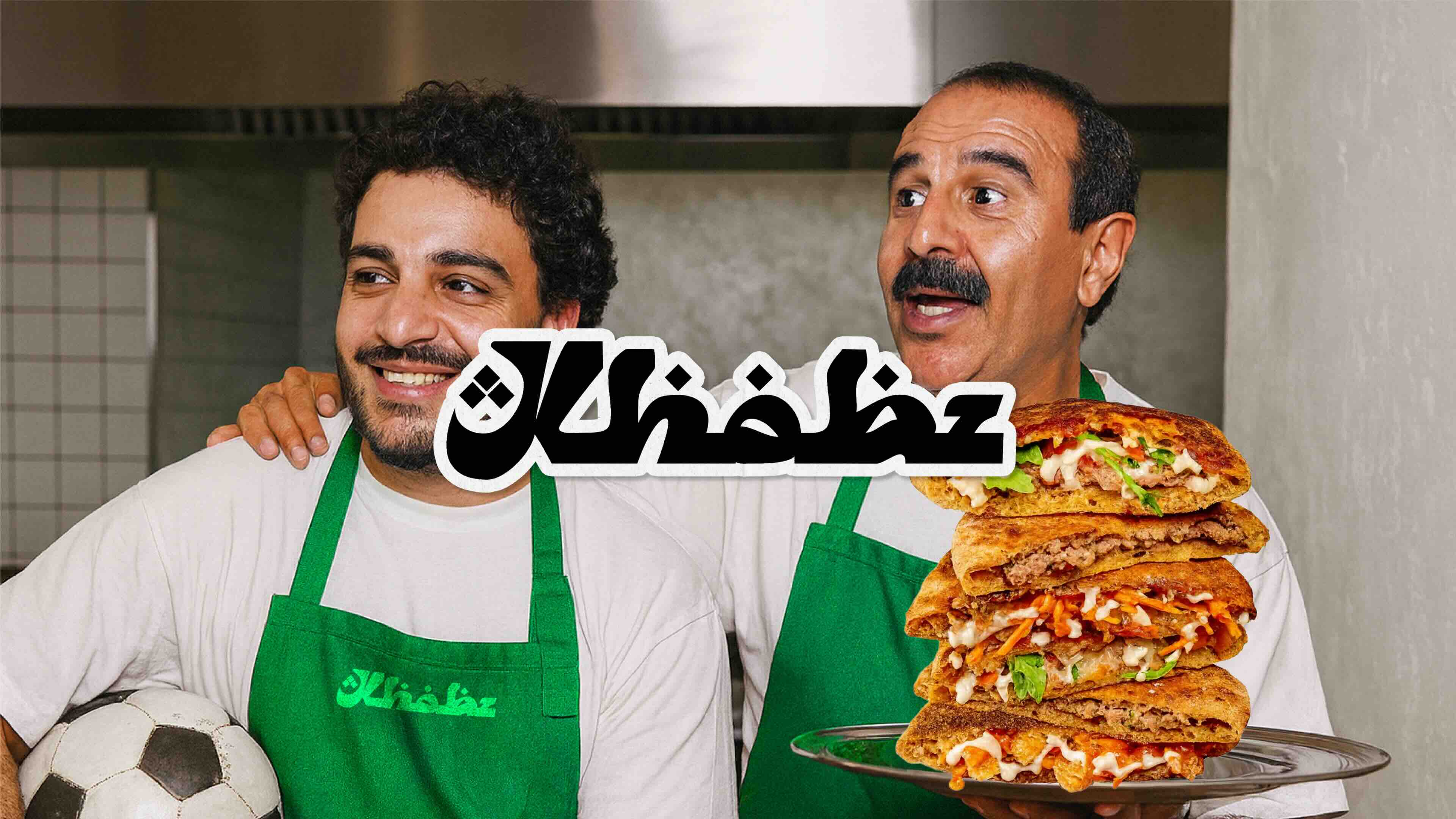 Hands holding a fried chicken burger in a branded Metz box and a serving of fries with cheese sauce in a blue container.