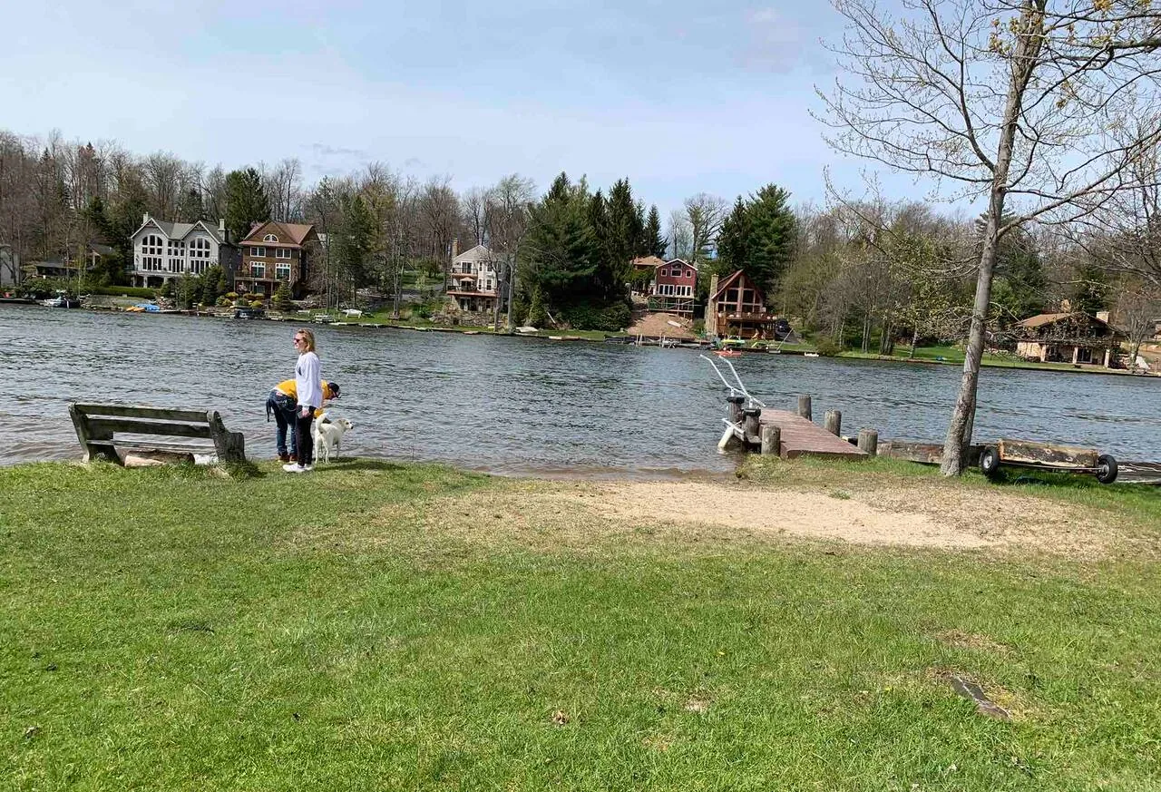 Grassy lake access point with bench and small beach near Lake Harmony, PA